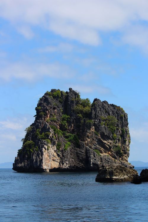 Free Stunning view of rugged island cliffs rising from tranquil sea under a clear blue sky. Stock Photo