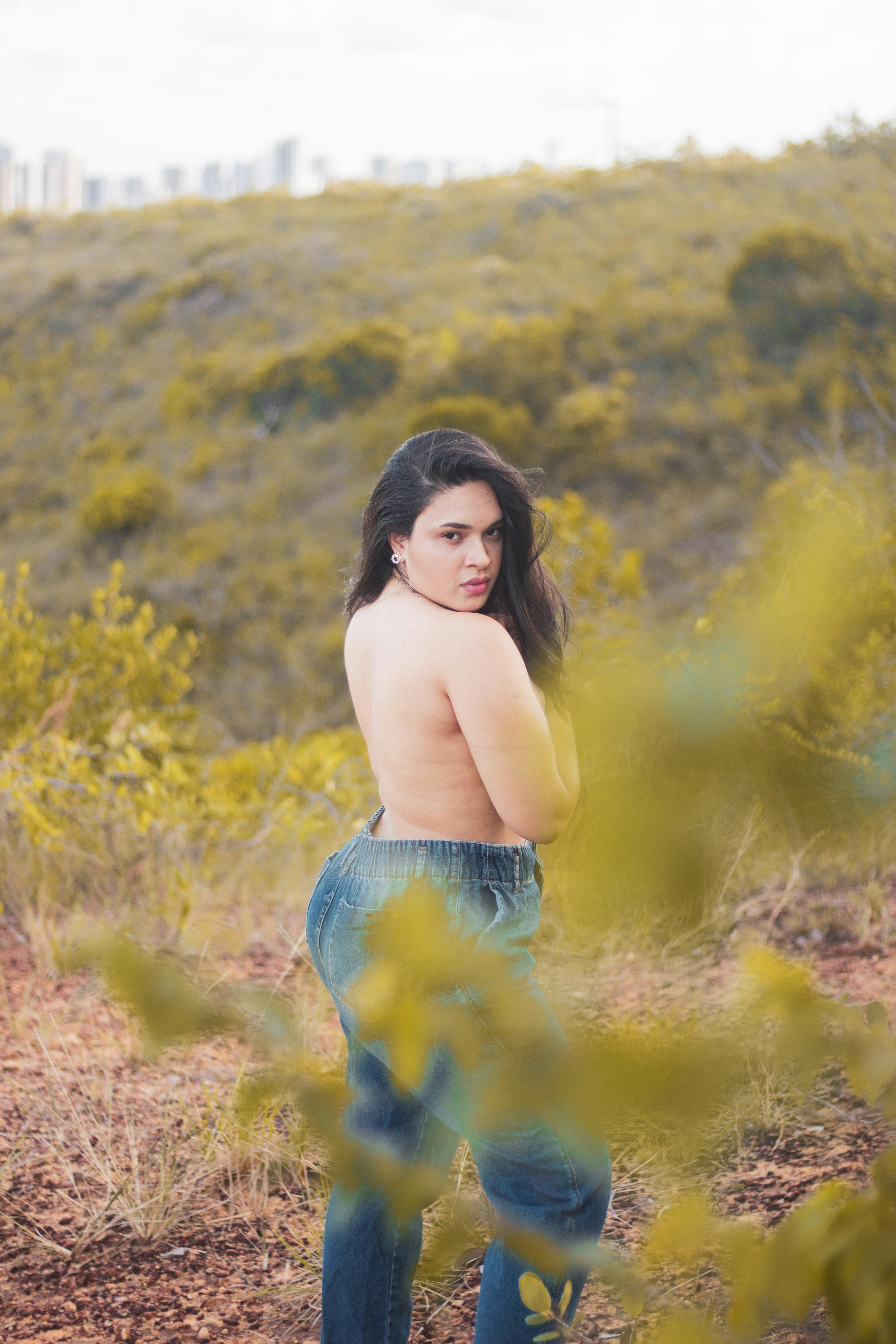 a woman in jeans standing in the woods