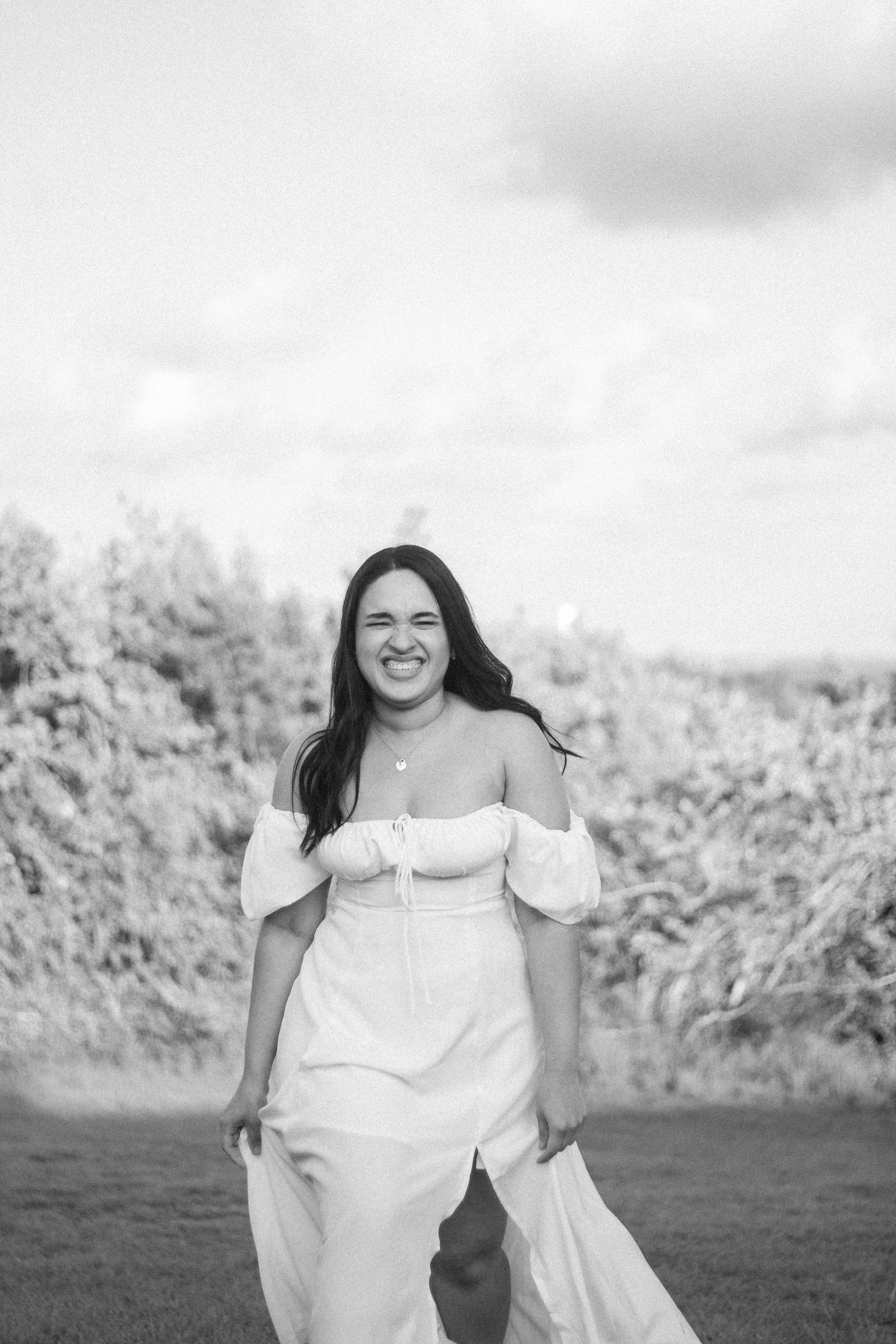 a woman in a white dress smiles for the camera