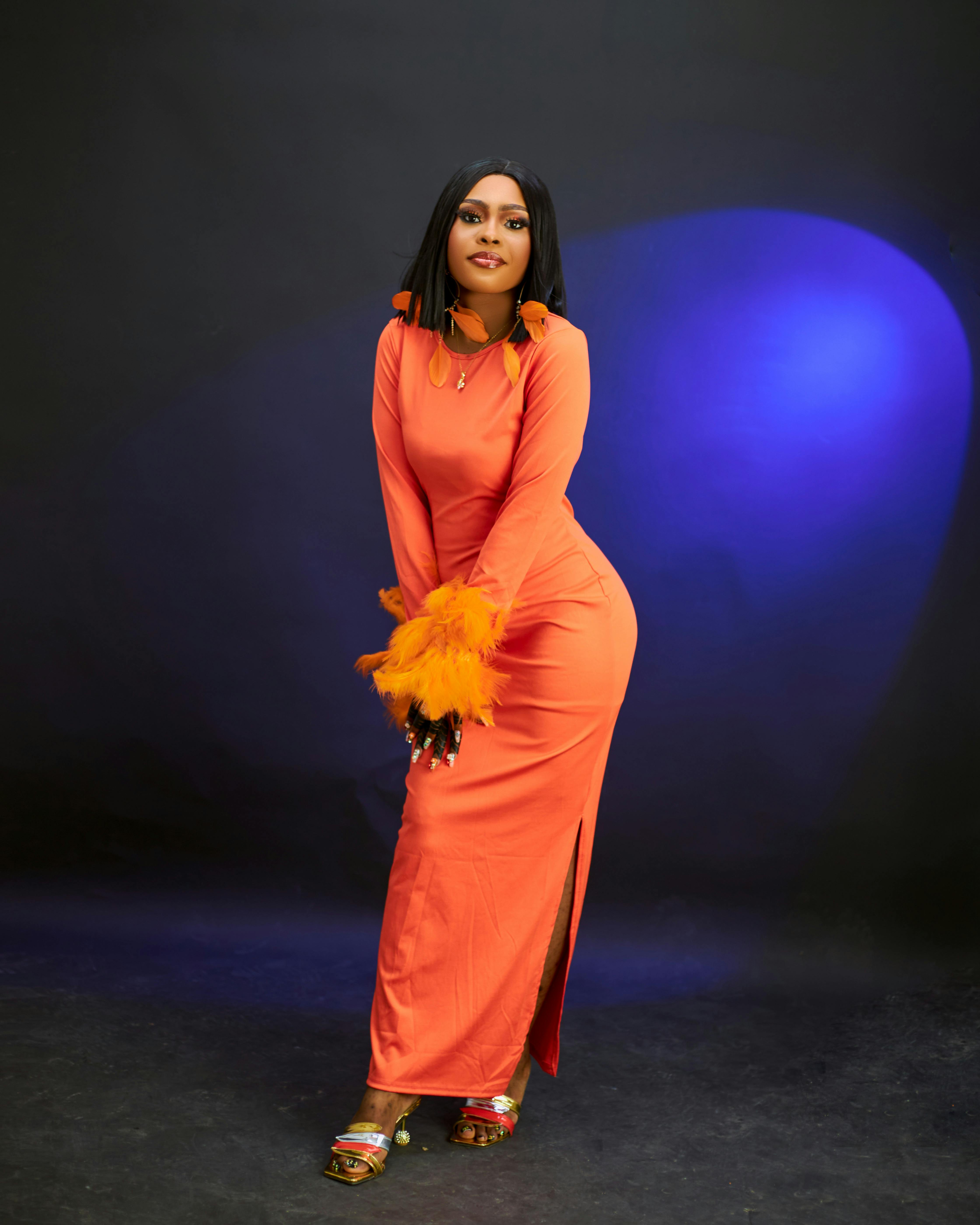 a woman in an orange dress posing for the camera