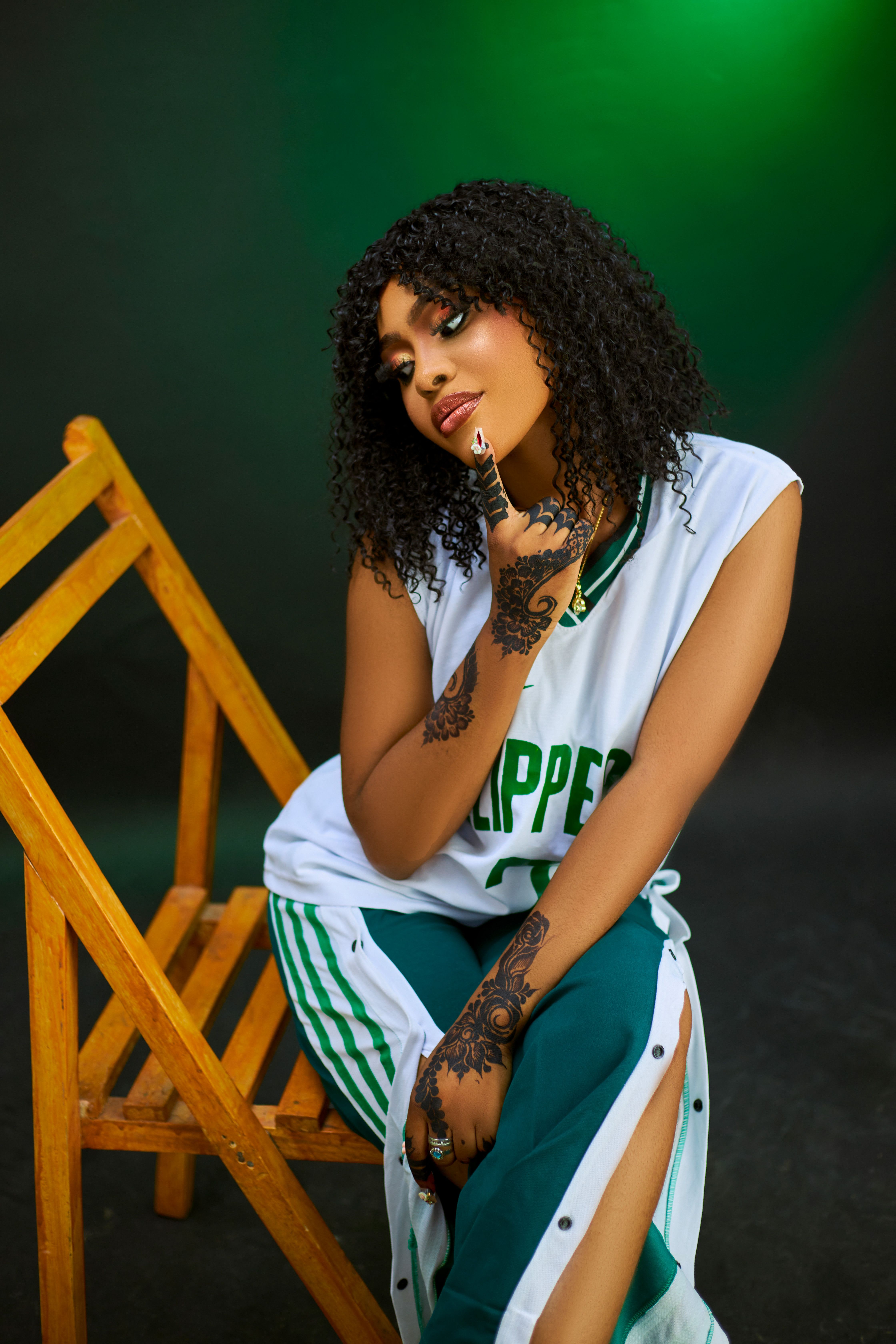Fashionable young woman poses in sports jersey with henna tattoos.