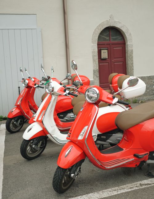 Free Three vibrant retro scooters parked in a row against a vintage urban backdrop, showcasing classic design. Stock Photo