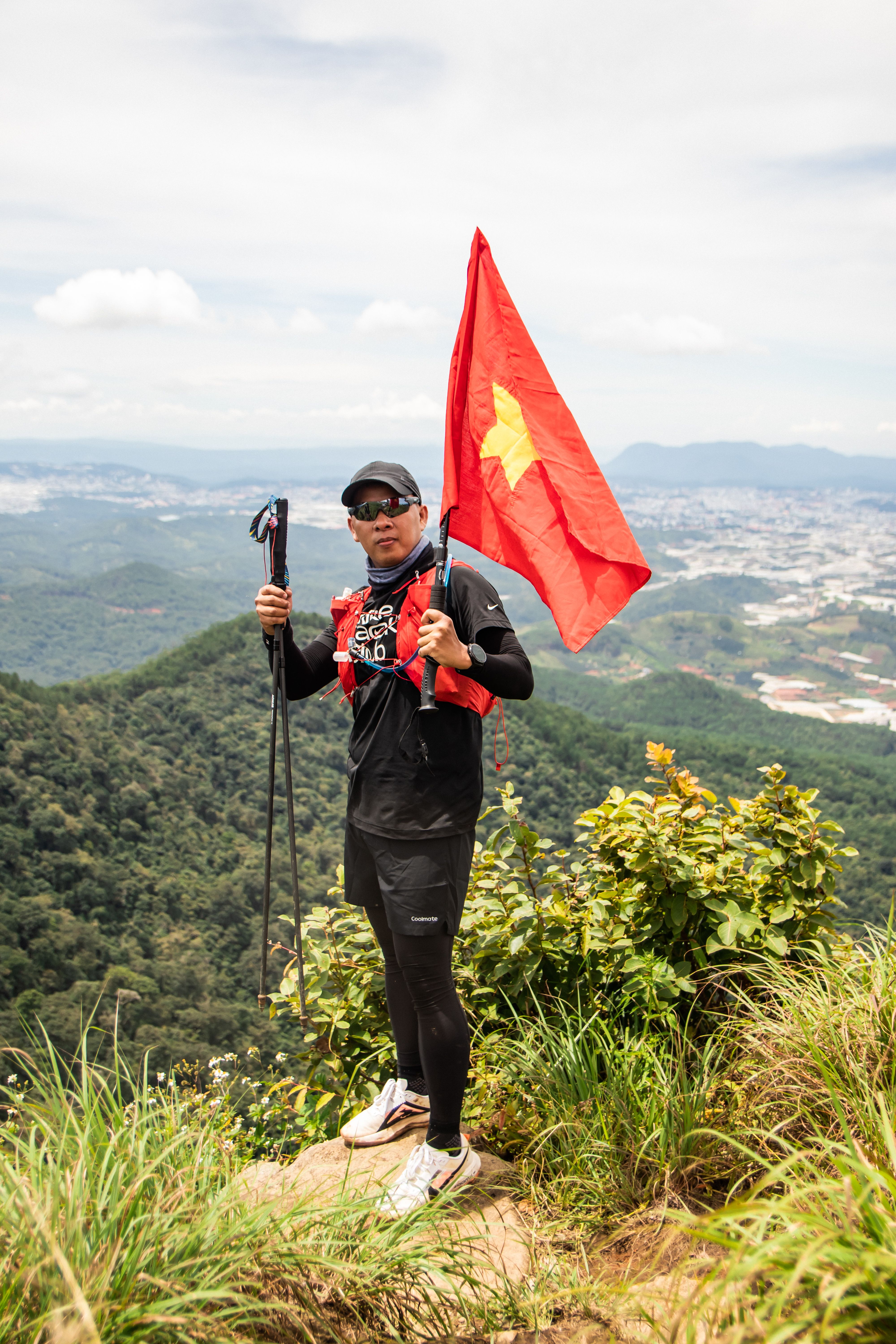 A man holding a red flag on top of a mountain · Free Stock Photo