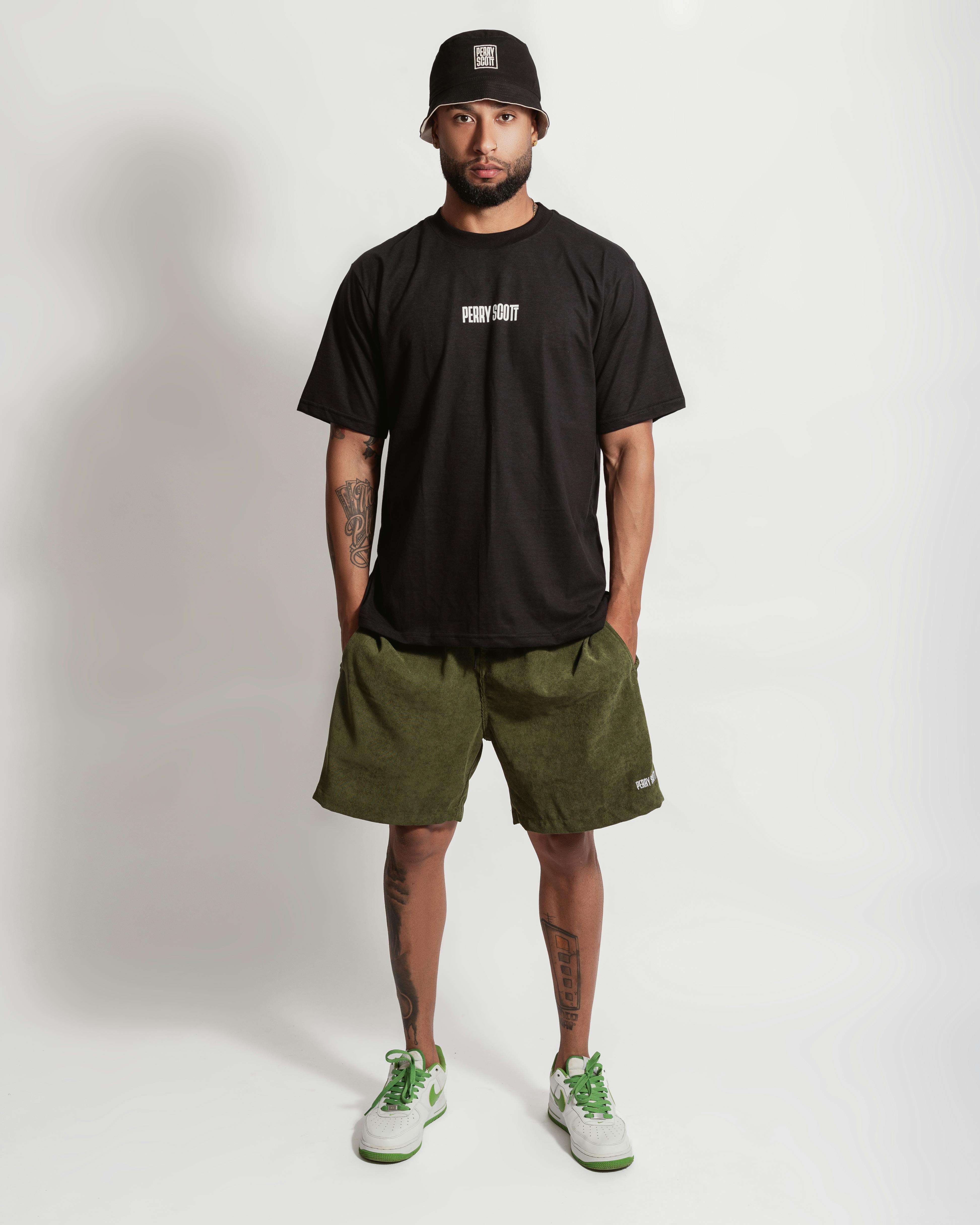 a man in black t shirt and green shorts