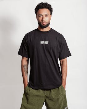 Stylish young man in a black t-shirt with text, displaying contemporary fashion.