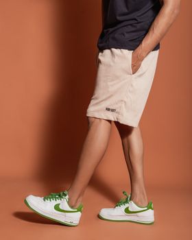 Model showcasing casual summer fashion with white and green sneakers.