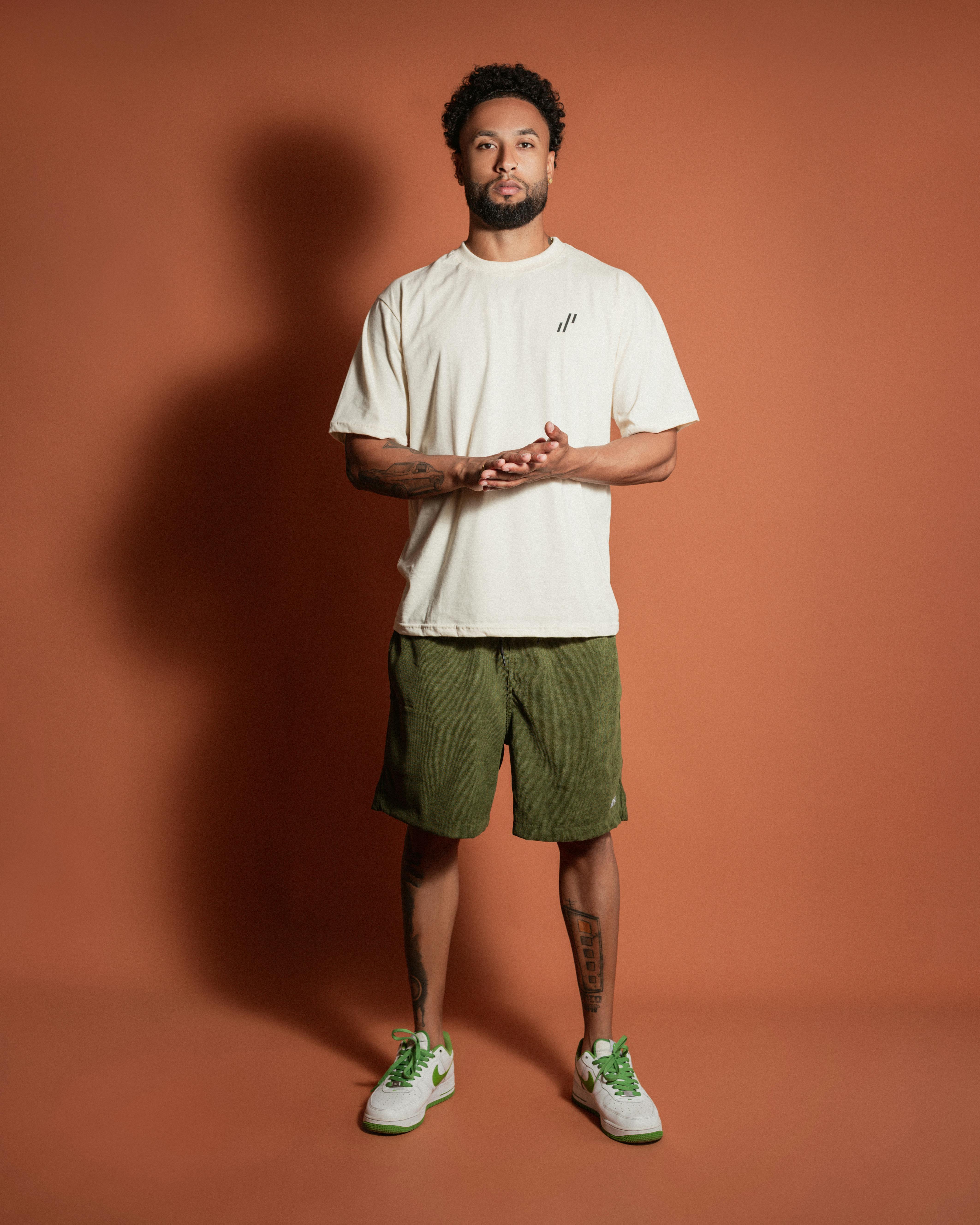 a man in shorts and sneakers standing in front of a wall