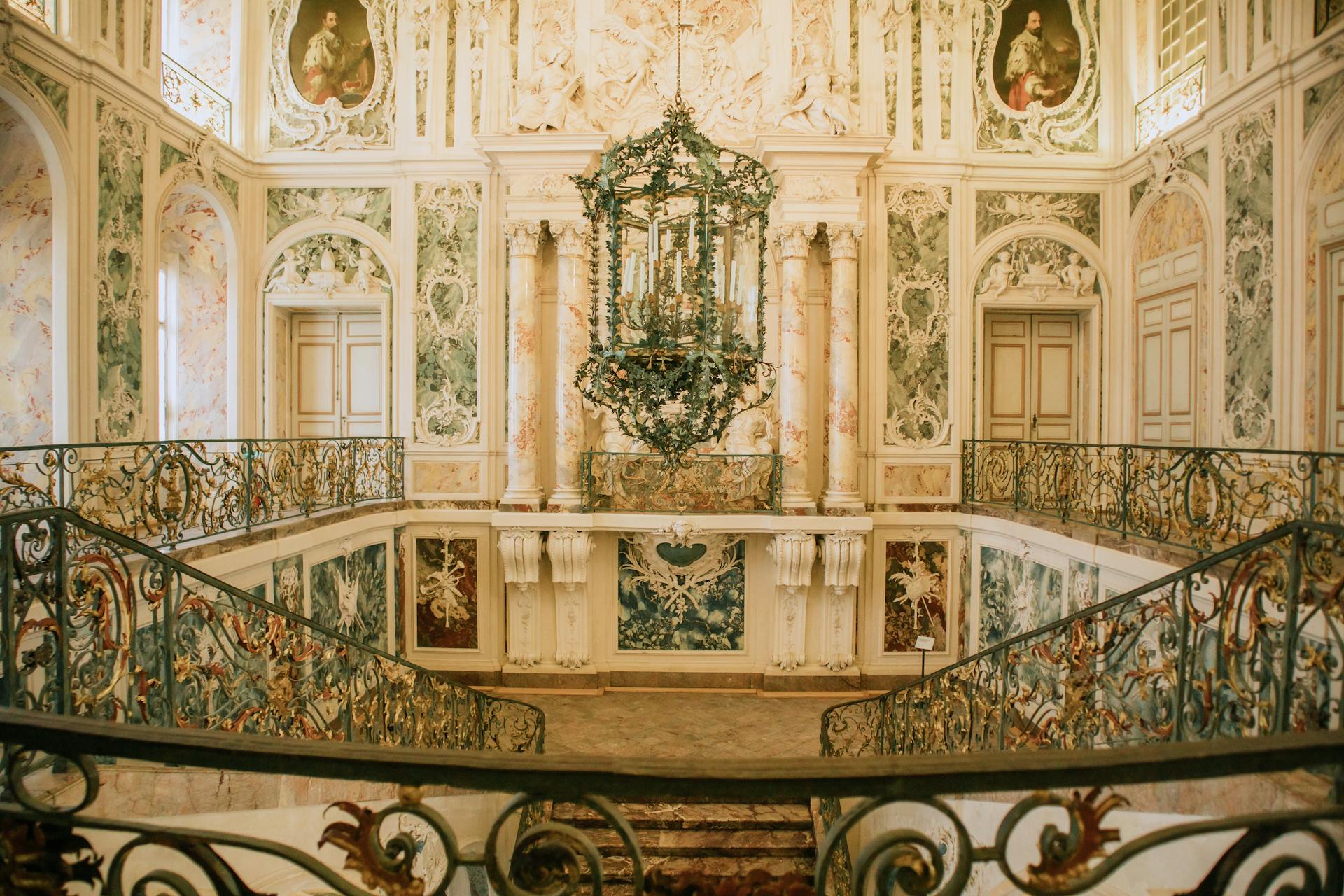 A staircase in a fancy building with ornate chandeliers