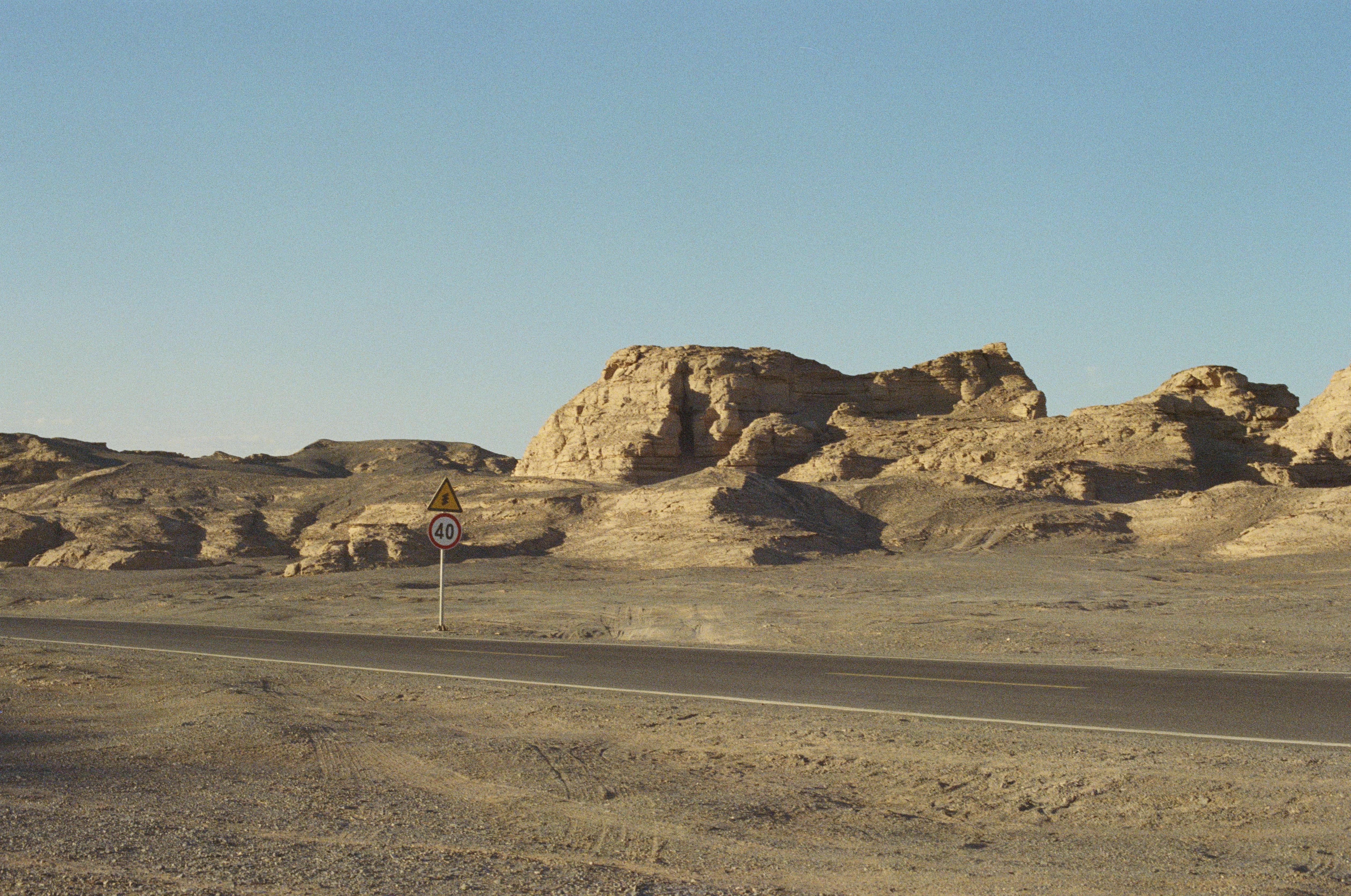 a desert road with a sign that says road