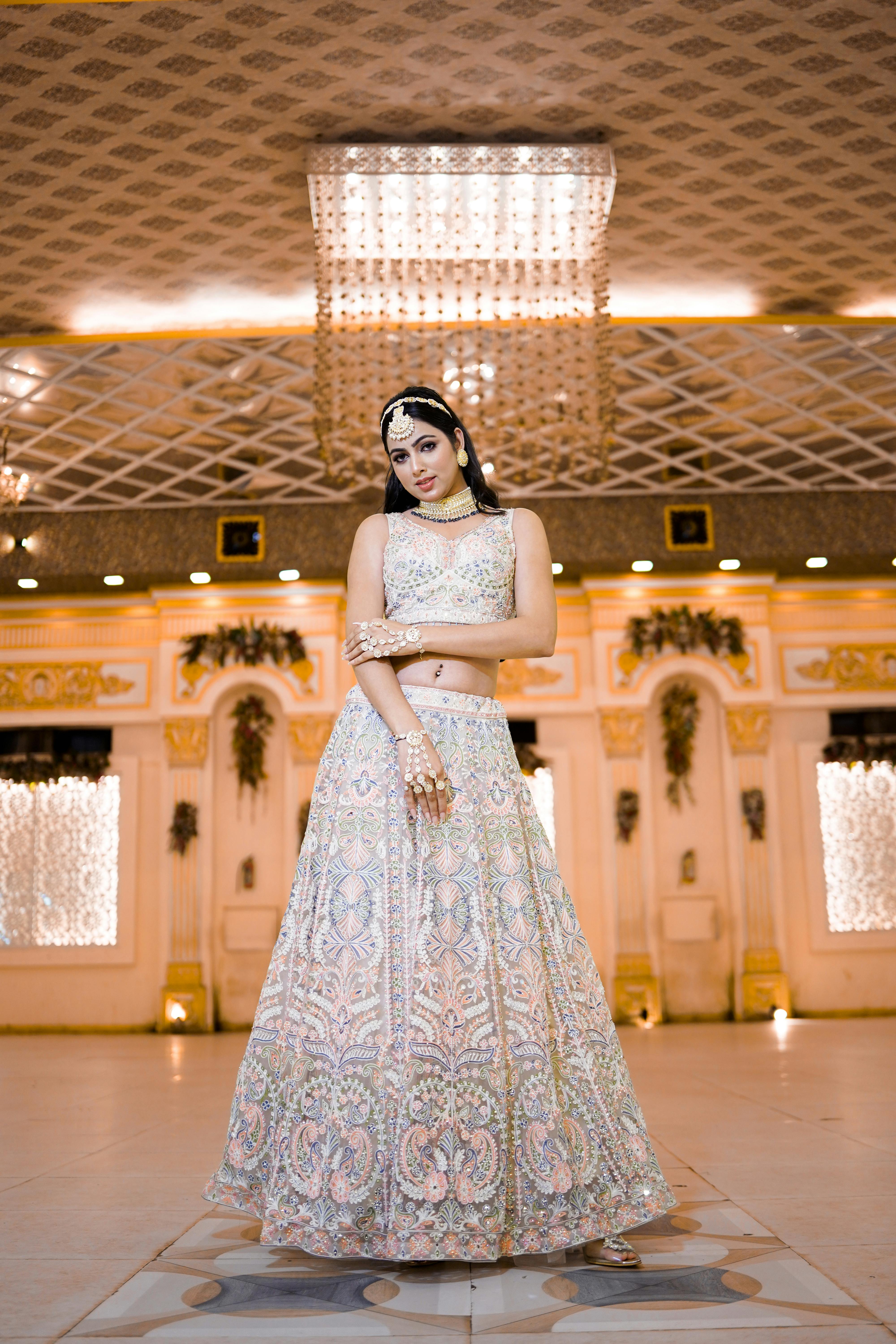 Stylish Indian bride posing elegantly in a luxurious indoor setting with intricate decor.