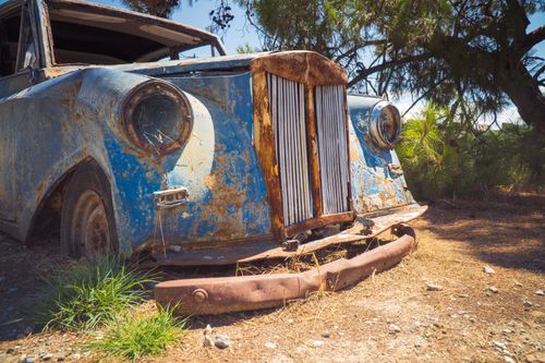Free A forgotten vintage car rusts away outdoors, showcasing its decay and history. Stock Photo
