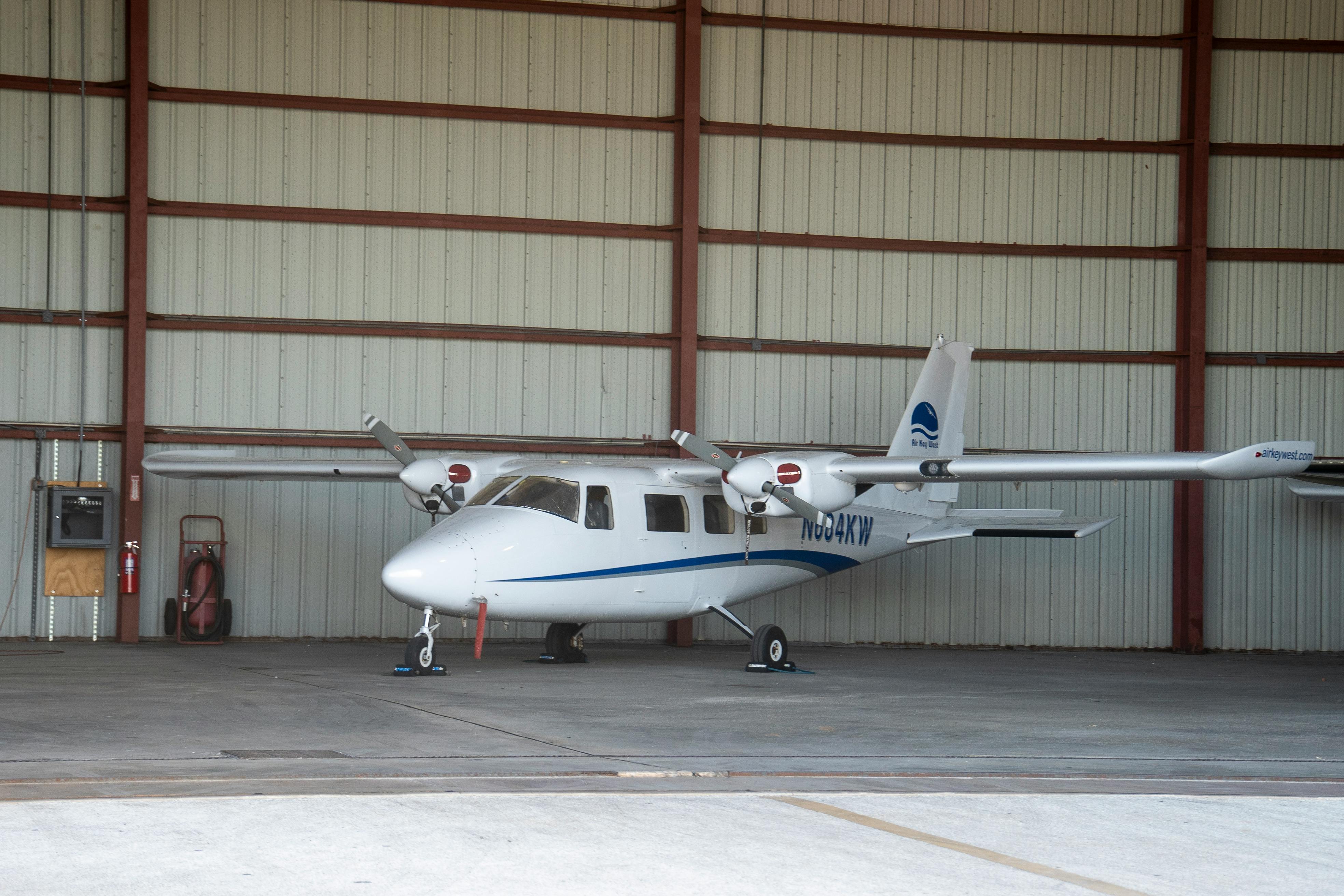 A small white airplane parked inside an aircraft hangar in Key West, Florida.