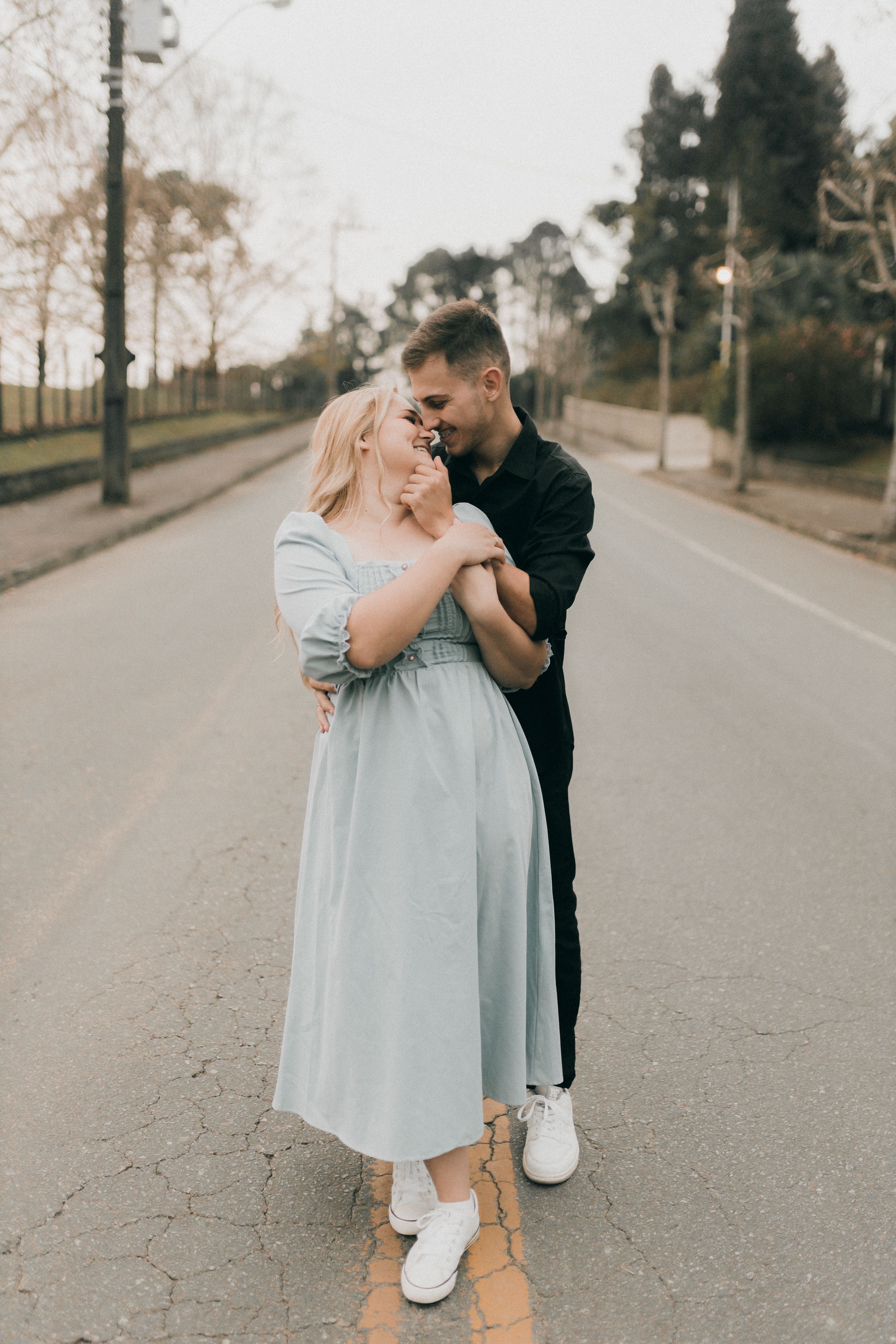 A couple hugging on the street in front of a building · Free Stock Photo