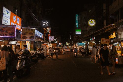 Free Explore the bustling night market with vibrant lights and active street vendors. Stock Photo