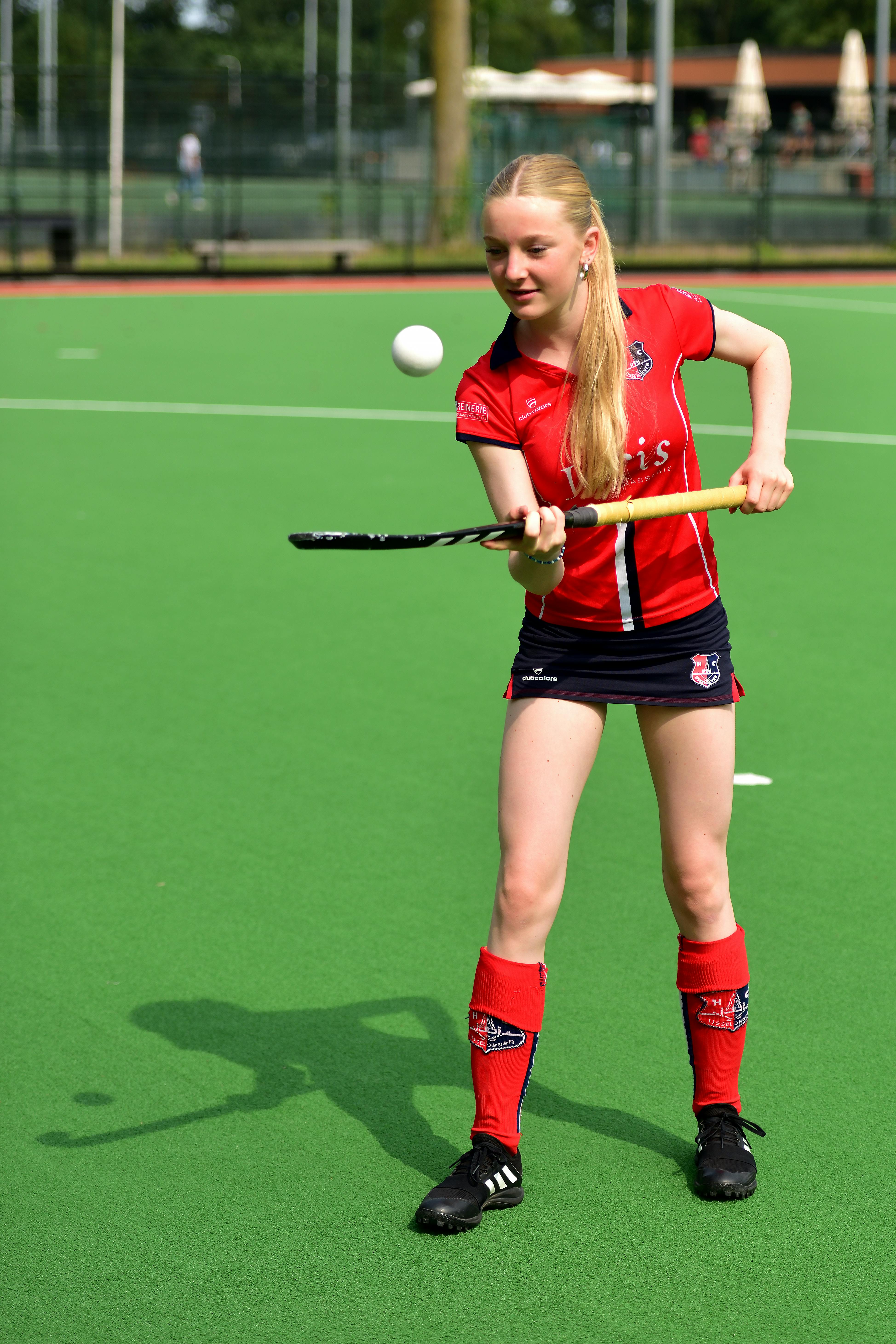 hockey speelster houdt bal hoog met hockeystick