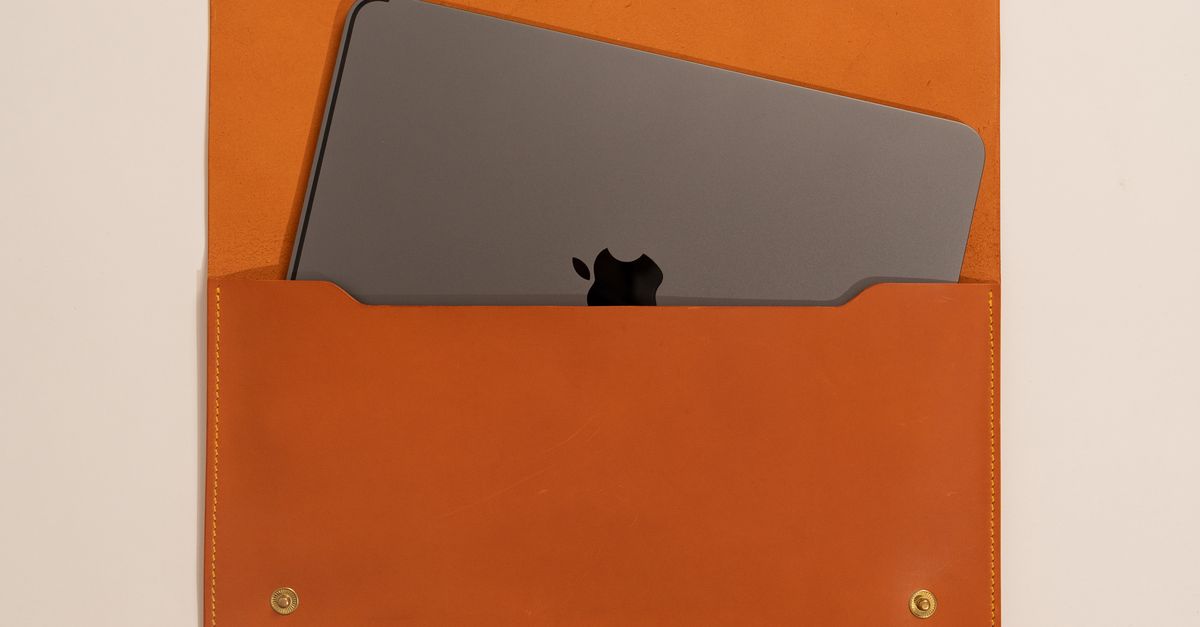 An apple laptop case with a leather strap · Free Stock Photo