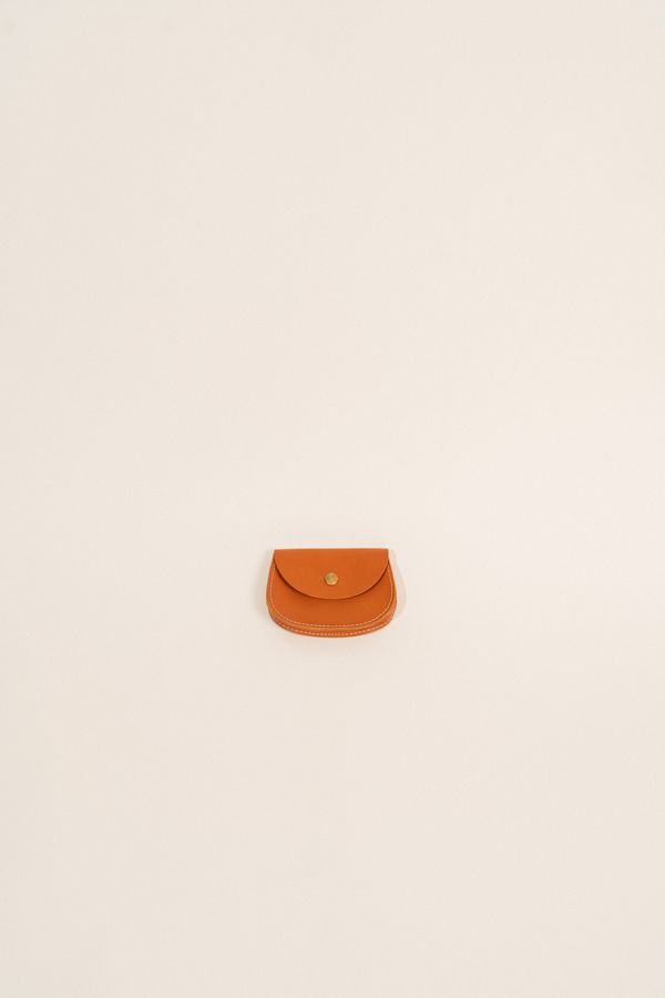 Small leather pouch on a plain sand-coloured backdrop — photo by Gul Isik on Pexels