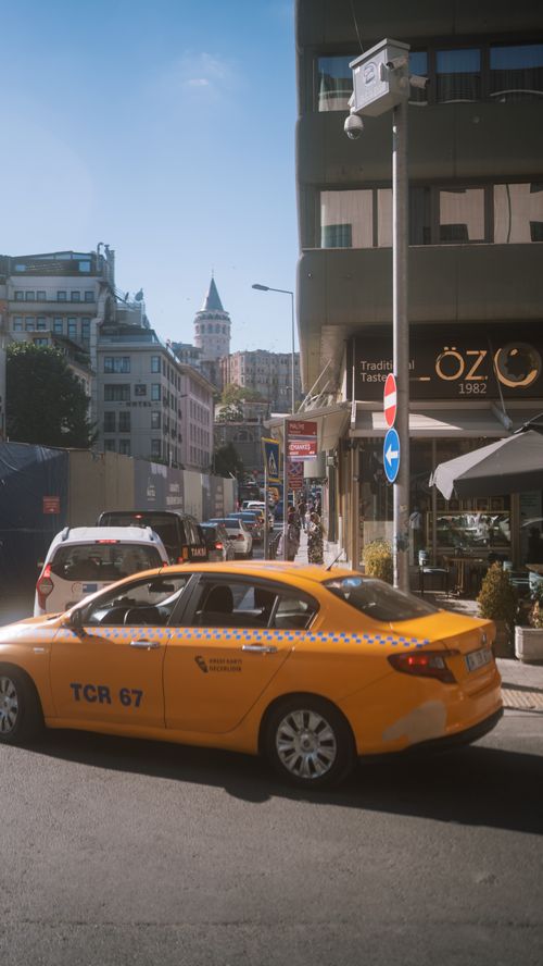 Free A vibrant street scene in Istanbul featuring a taxi and the iconic Galata Tower in the background. Stock Photo