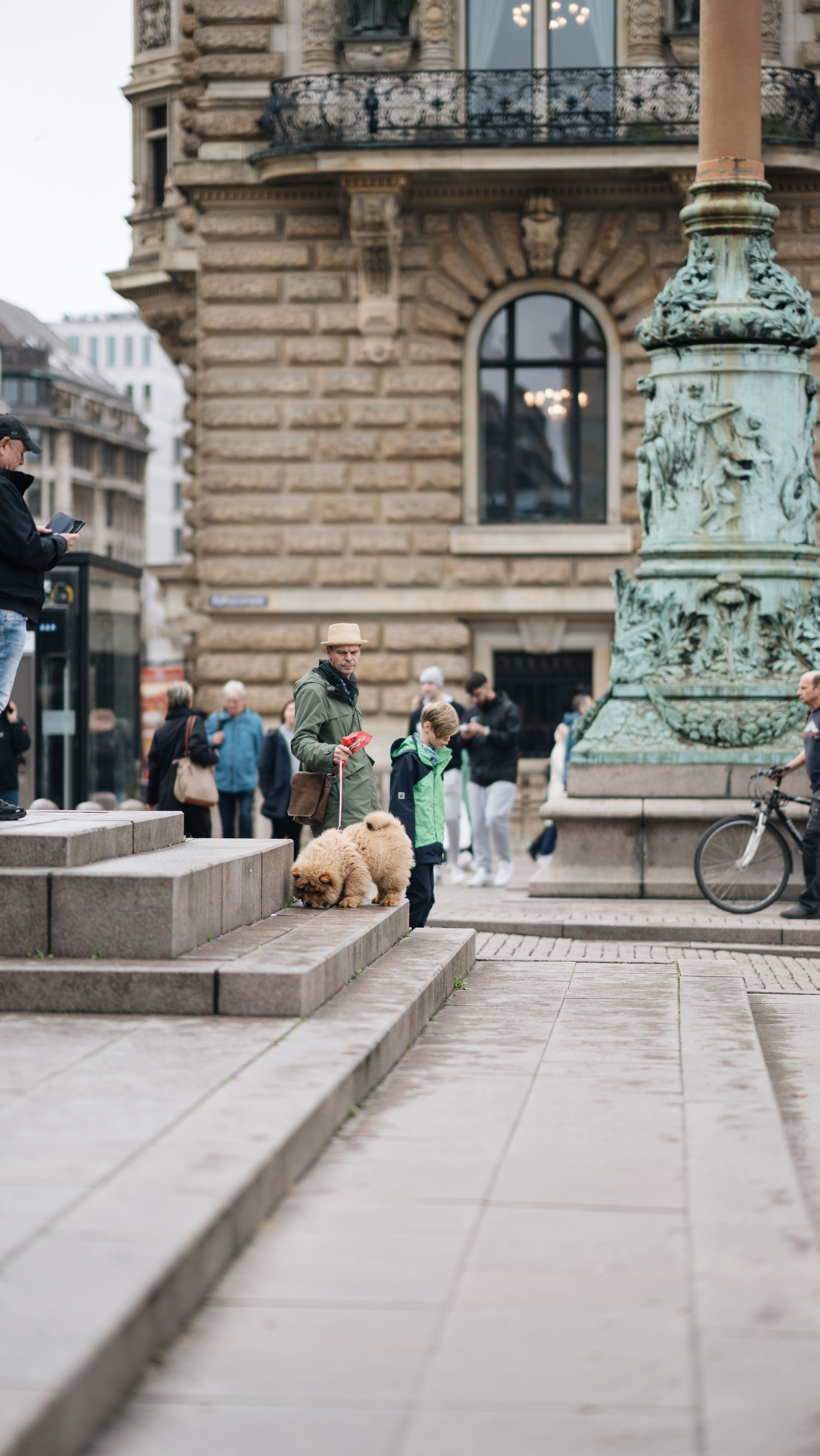 People and dog exploring urban city area with historical architecture and street life.