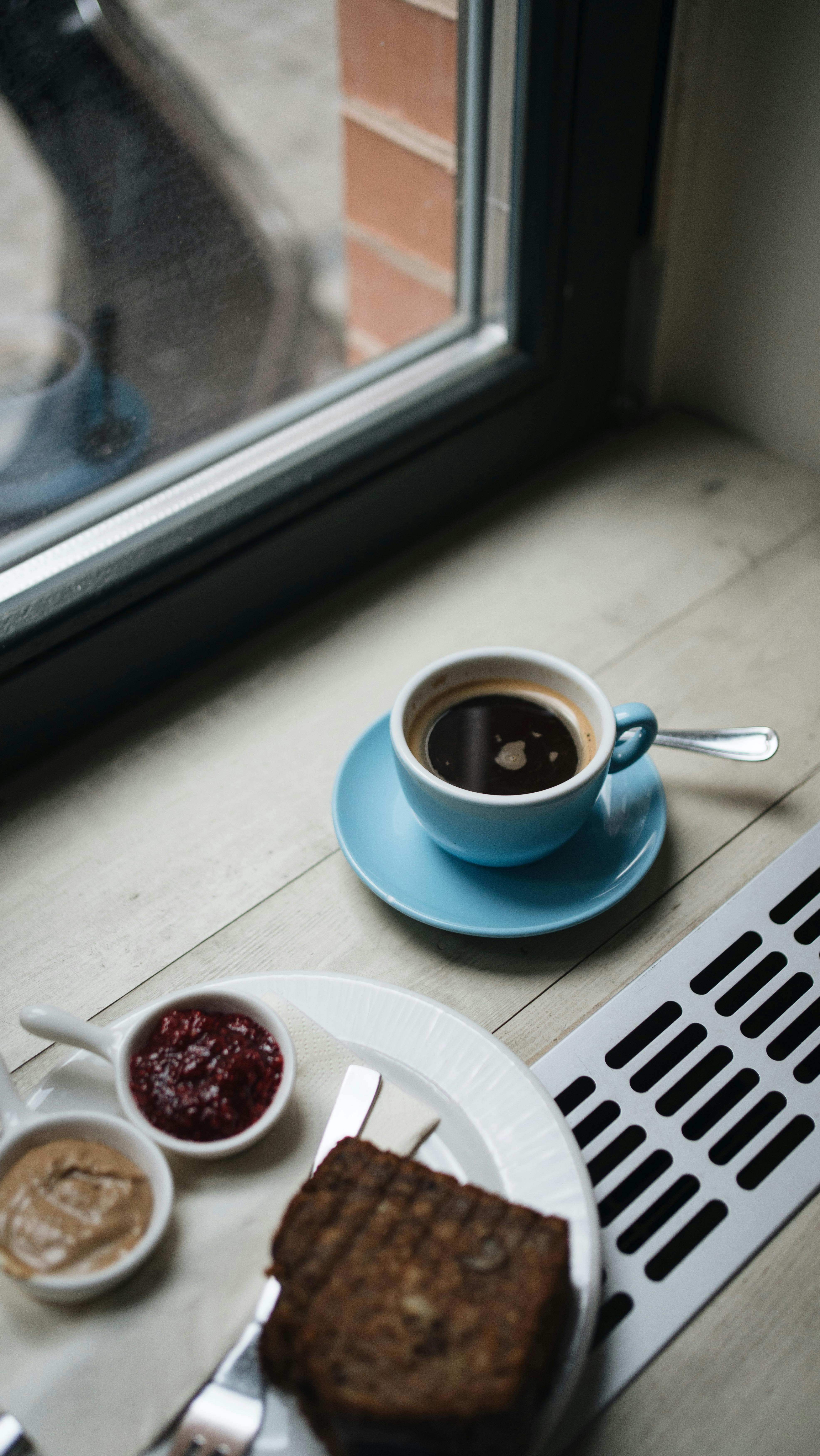 A cozy scene featuring coffee and toast on a windowsill creating a perfect breakfast ambiance.
