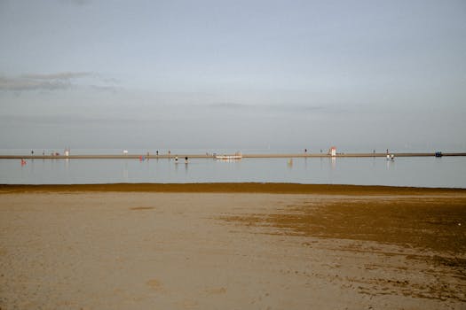 A serene beach scene with calm waters and distant people enjoying the view.