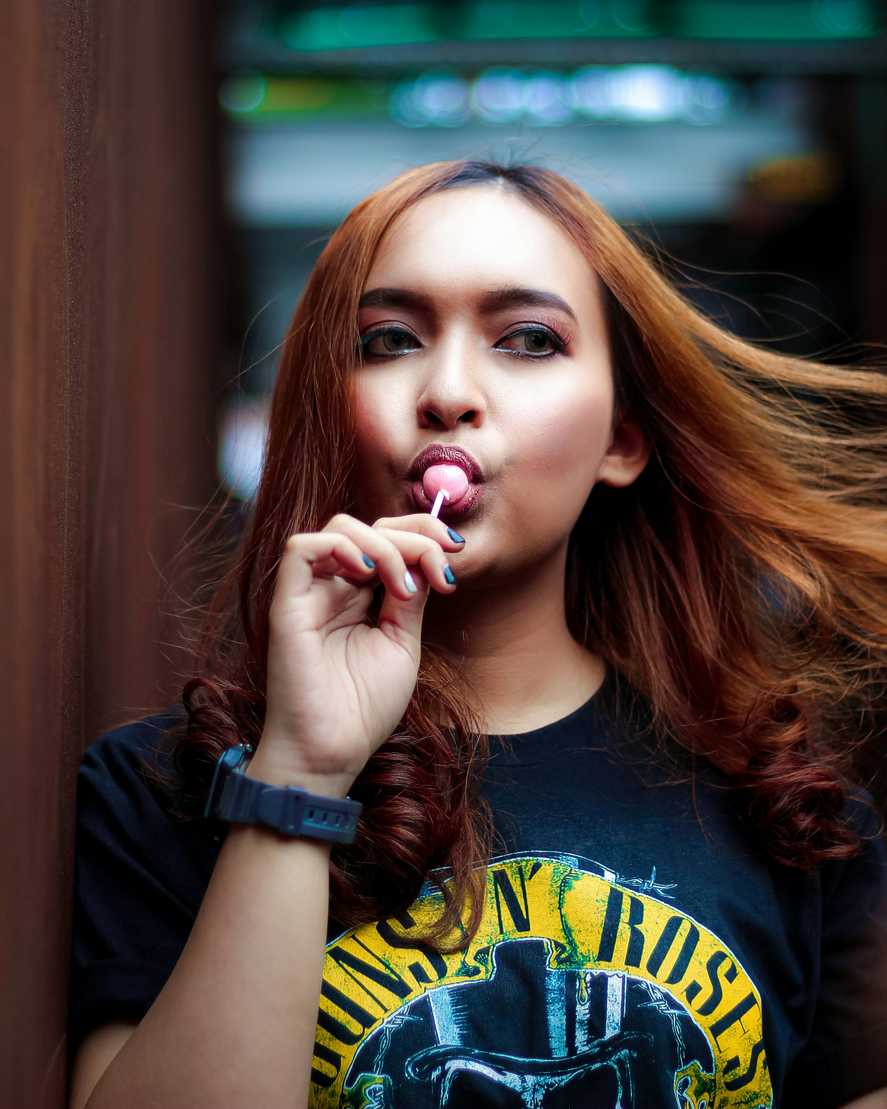 photo of woman eating lollipop