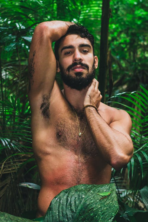 Free Photo of a Topless Man Surrounded by Plants Stock Photo