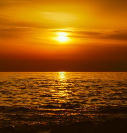 Free Captivating golden sunset reflecting over a calm ocean, creating a serene seascape. Stock Photo
