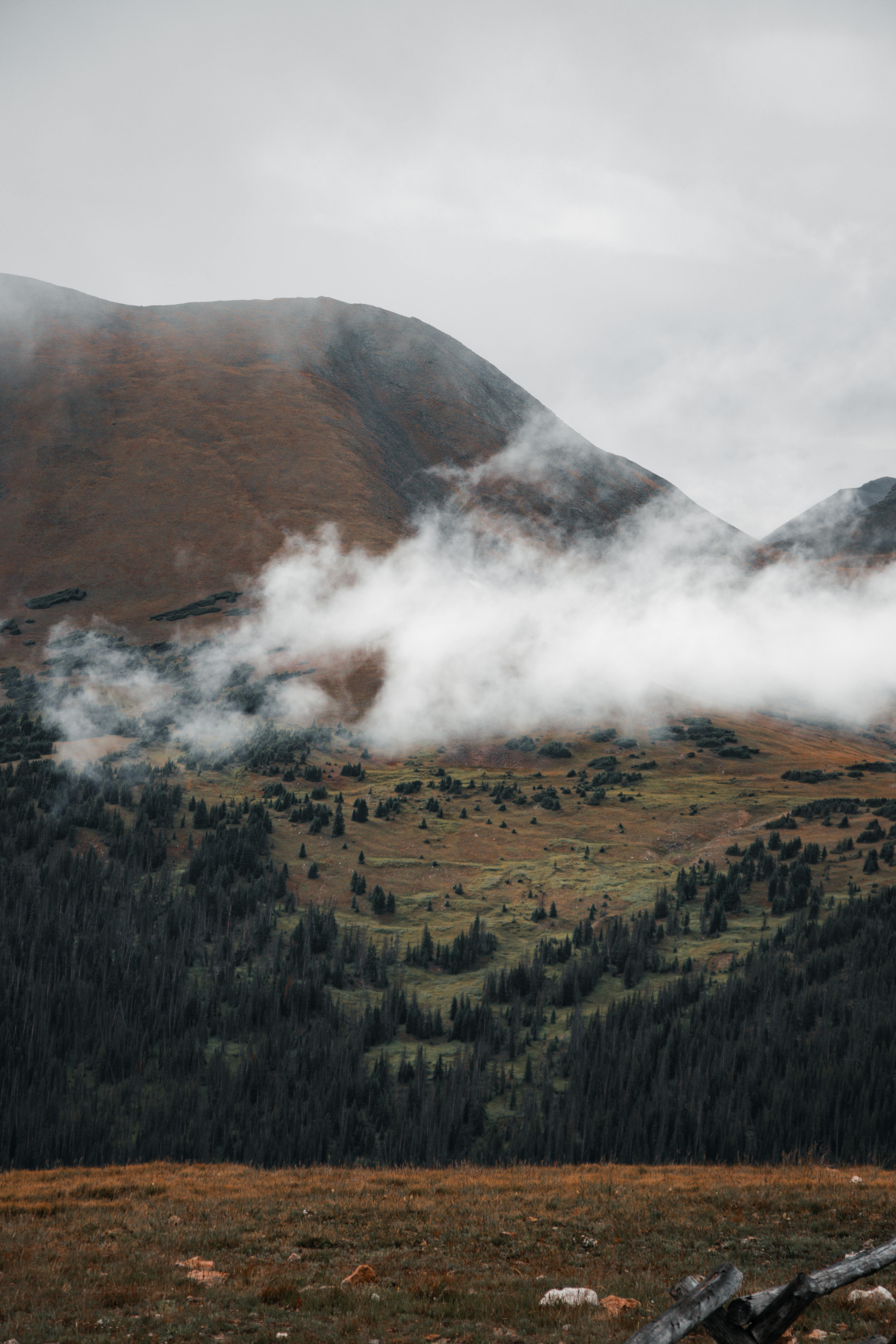 a mountain range with clouds and fog in the distance