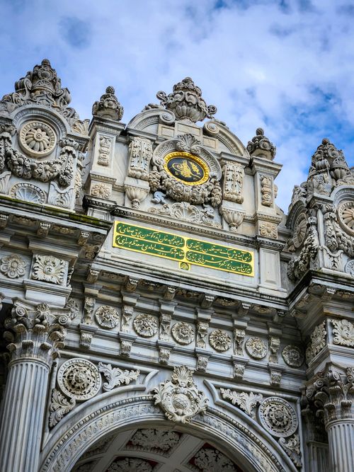 Free Ornately decorated gate showcasing intricate stonework and baroque architecture outdoors. Stock Photo
