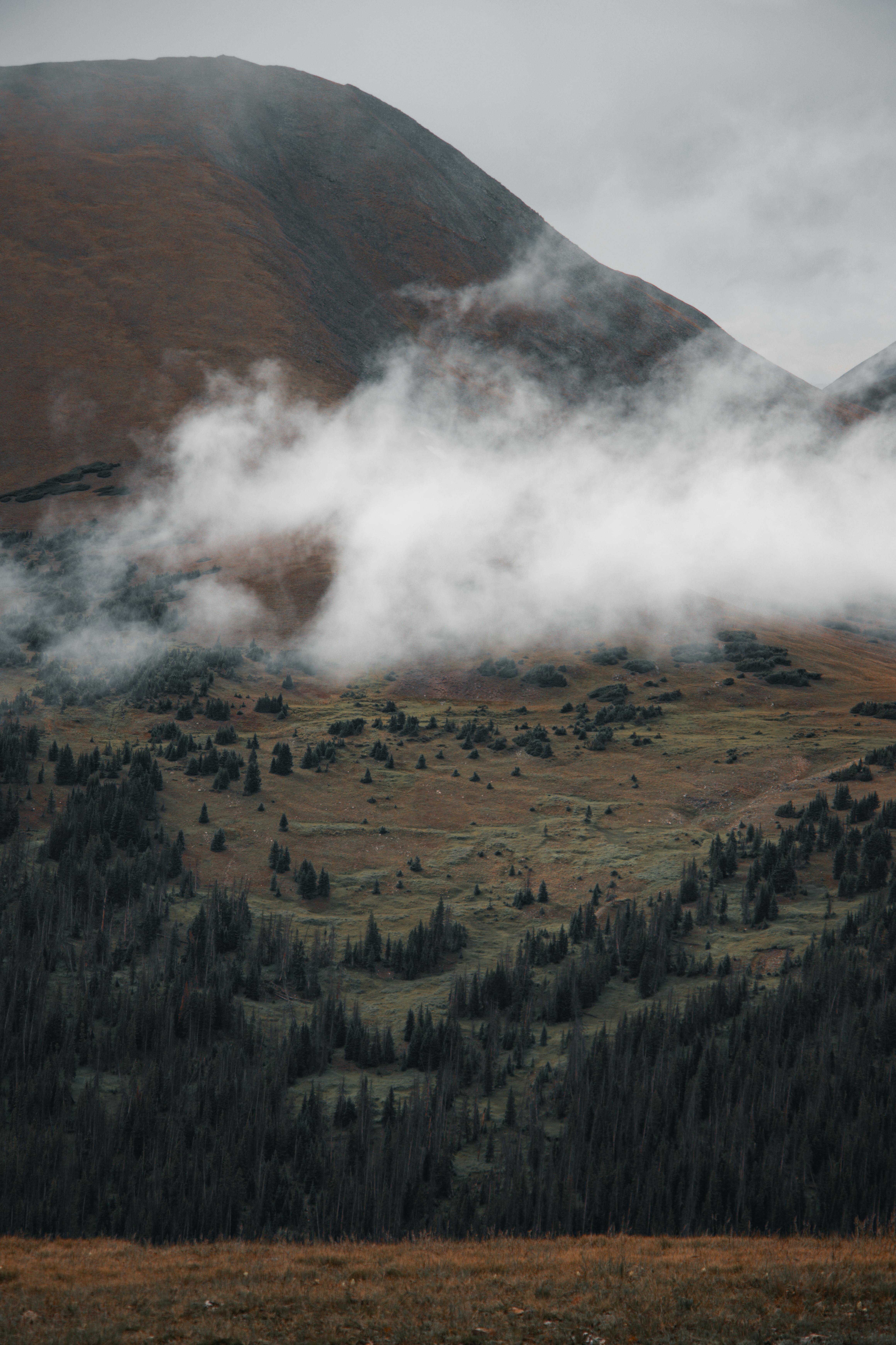 a mountain range with clouds and fog in the background