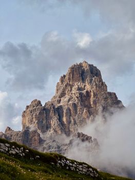 Breathtaking view of the rugged Dolomites in Versciaco, Italy, cloaked in mist and clouds.