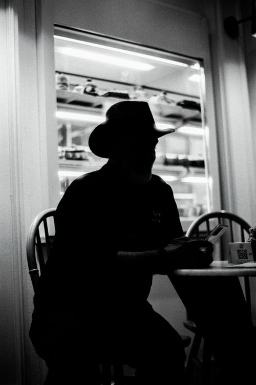 Free Black and white silhouette of a man with a hat sitting in a café in Istanbul. Stock Photo