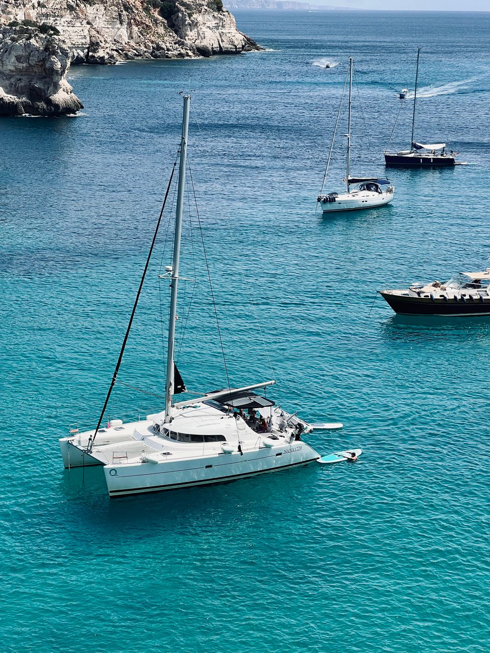 Voiliers naviguant près de falaises sur une mer turquoise