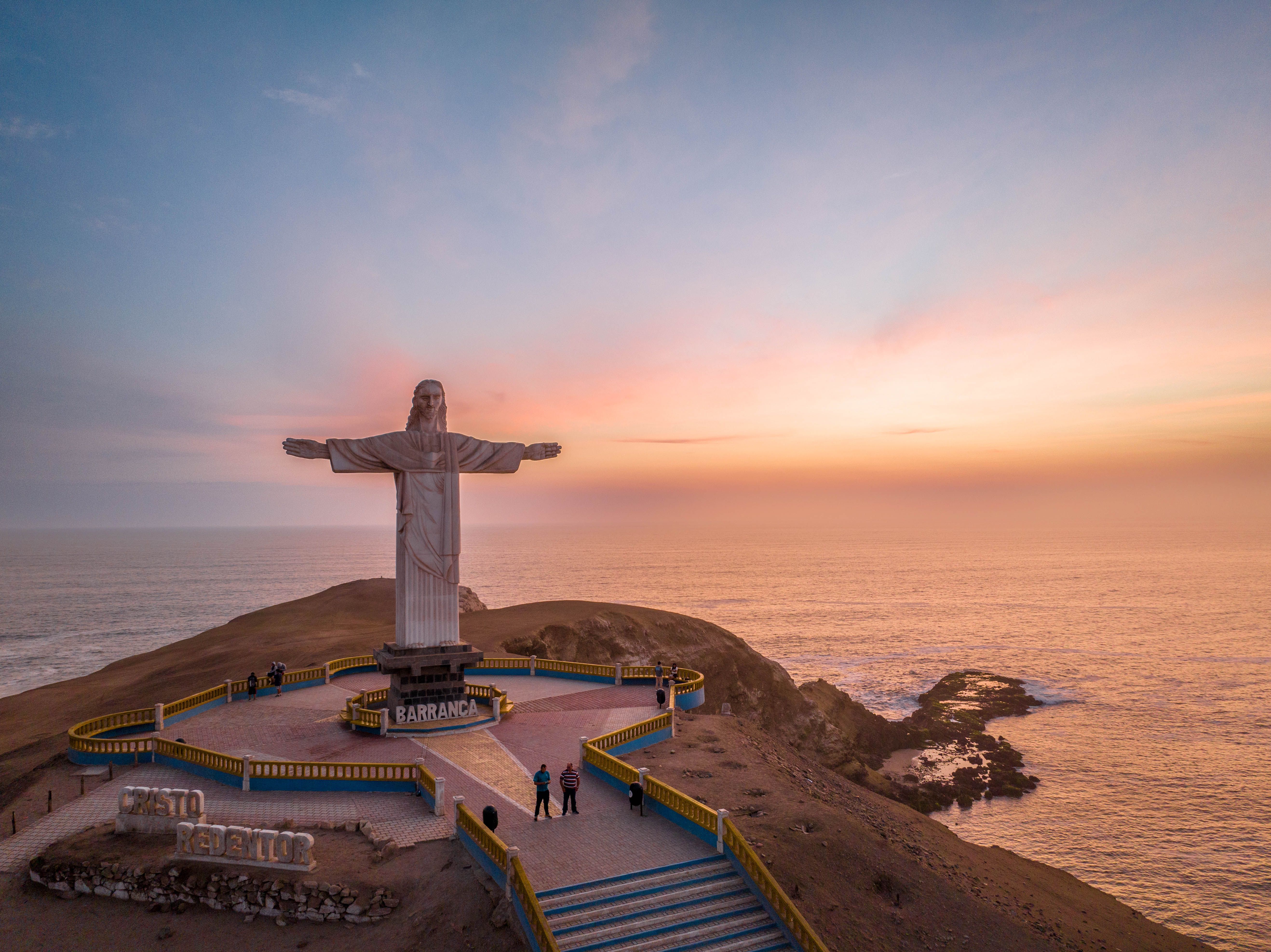 Captivating aerial view of Cristo Redentor at sunset in Barranca, Peru overlooking the ocean.