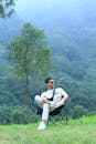 A man sitting in a chair in the middle of a forest