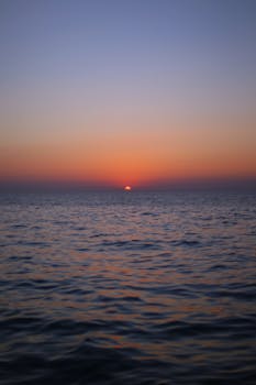 A tranquil ocean view at sunset, showcasing vivid colors and calm waters.