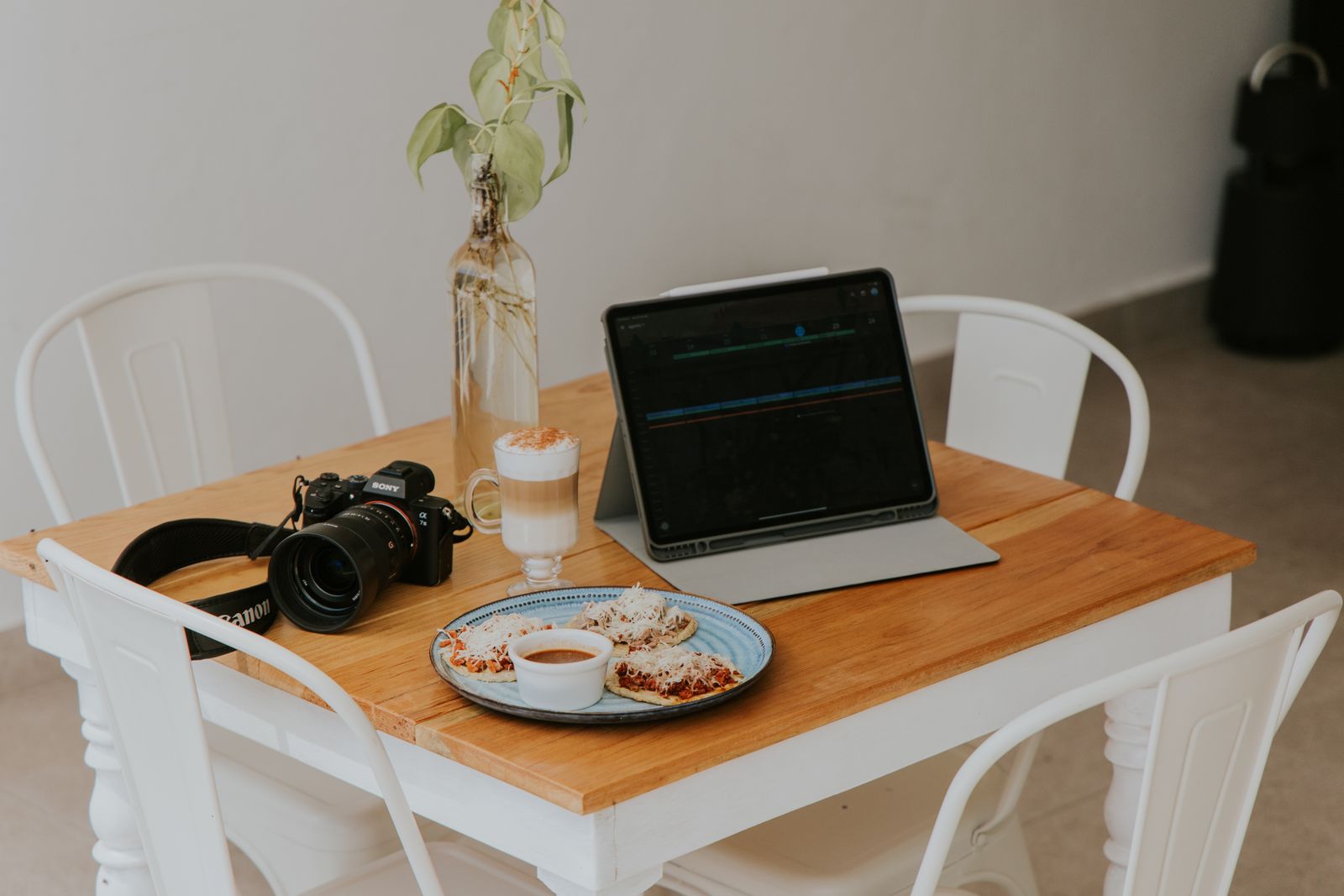 Laptop, camera, and food styling setup on a table.