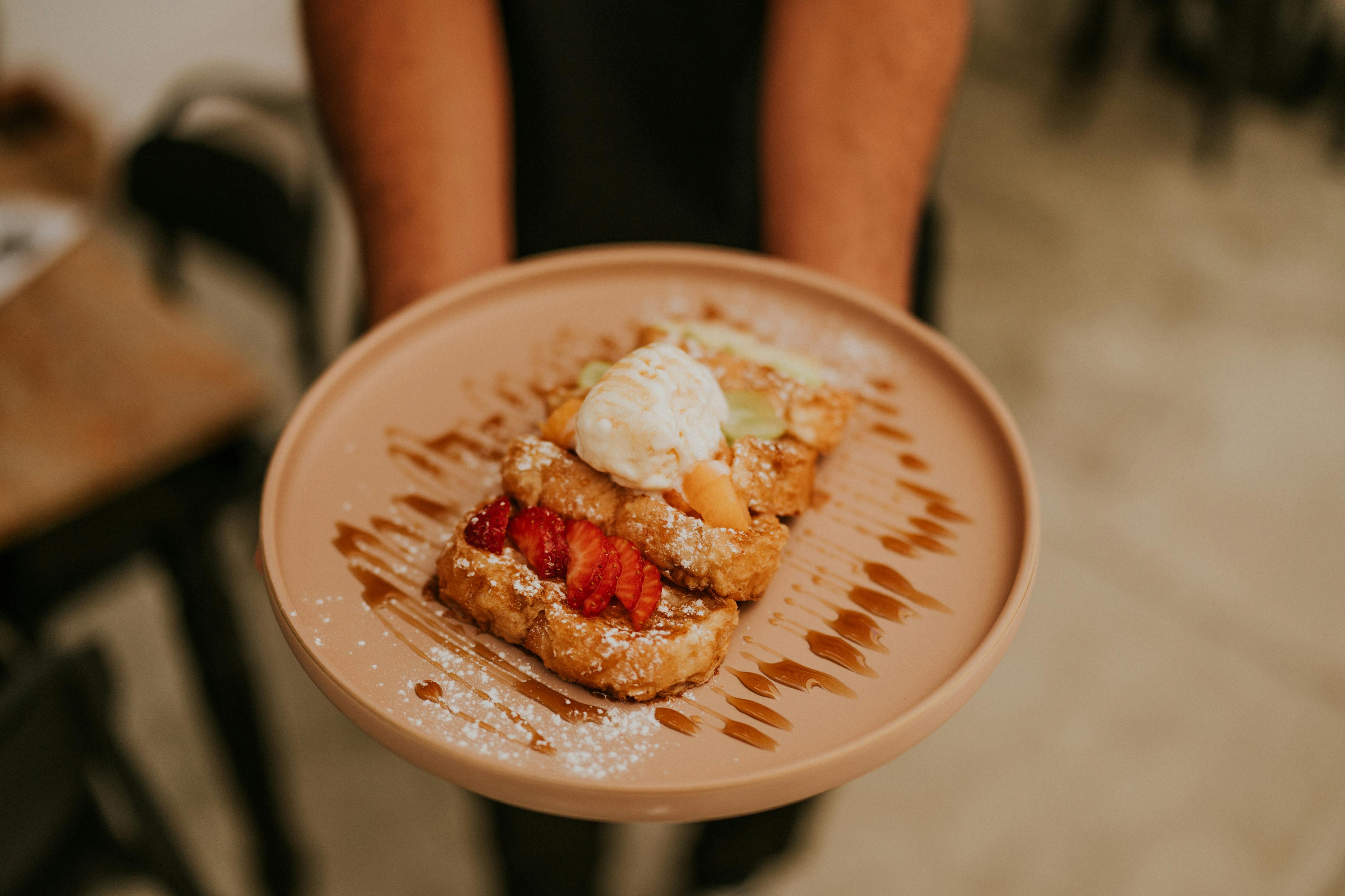 a person holding a plate with a dessert on it