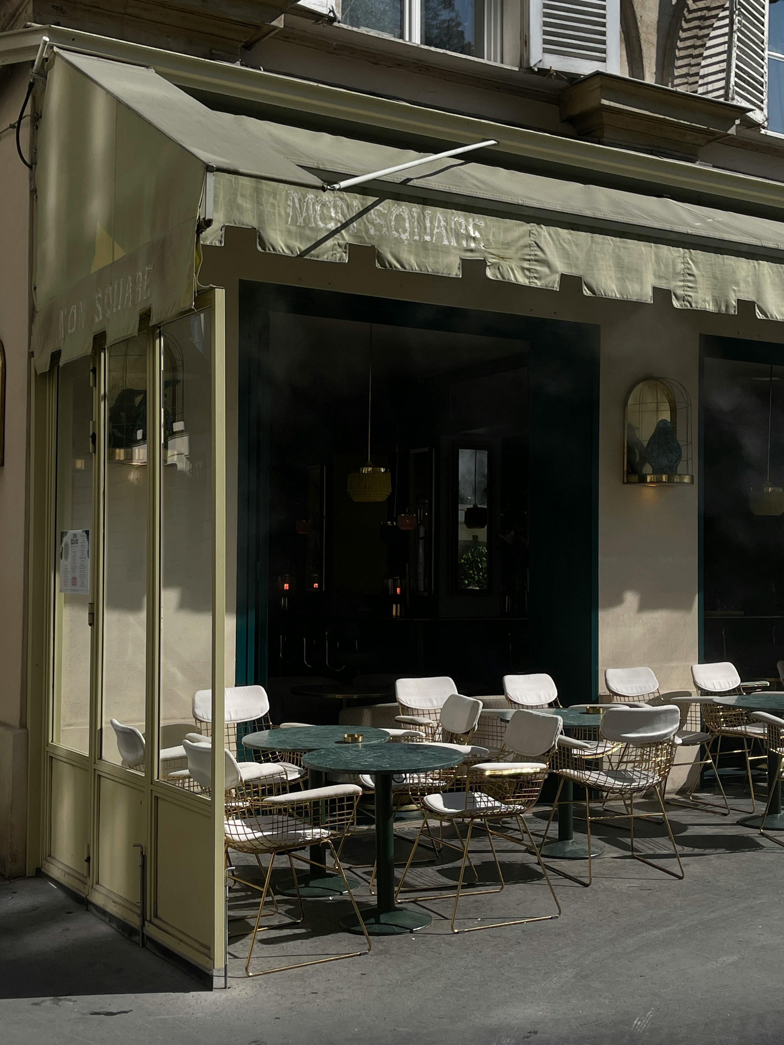 Cozy outdoor cafe with elegant seating in an urban area, perfect for social gatherings.