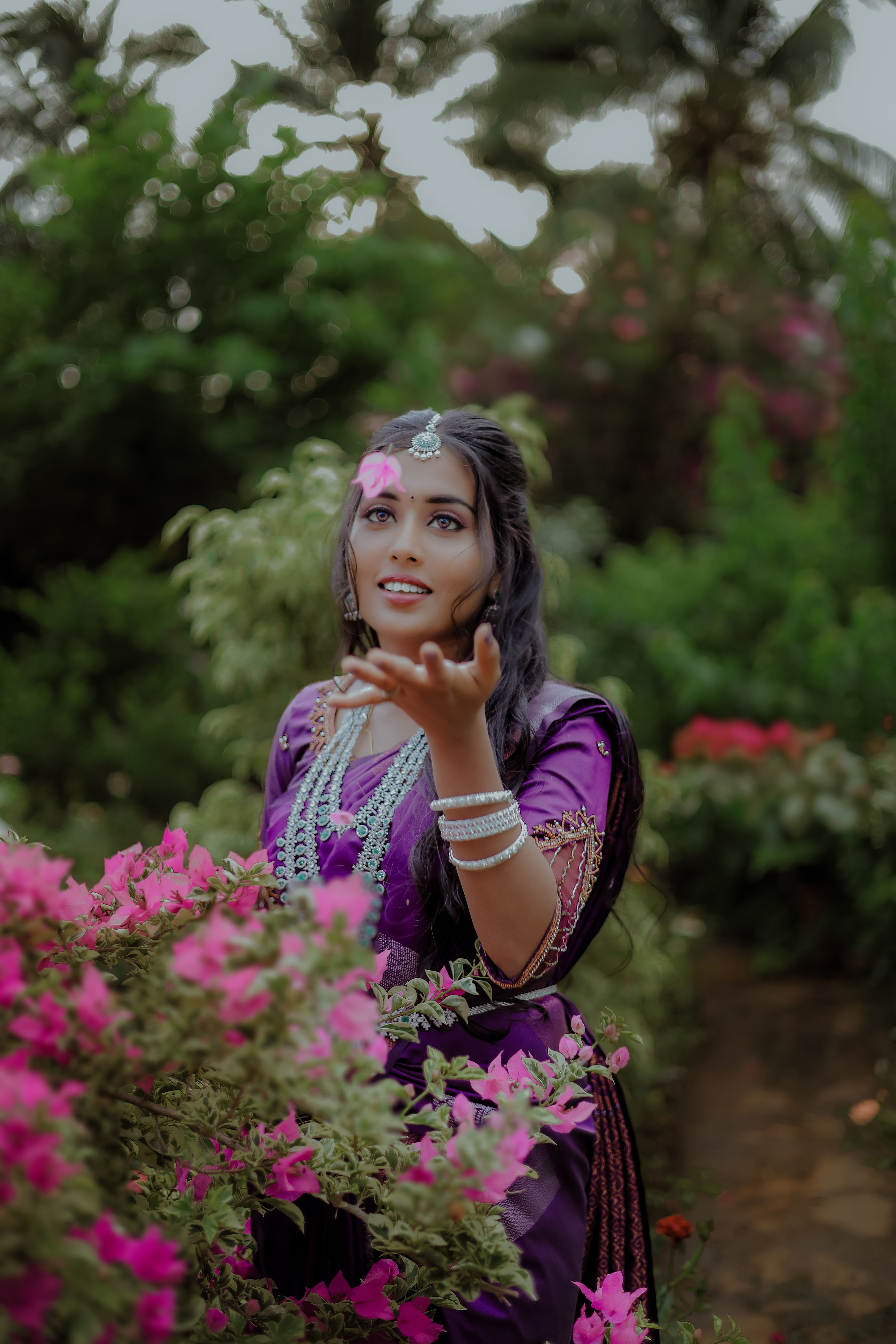 Charming portrait of an Indian woman in a vibrant garden, embracing the beauty of nature.