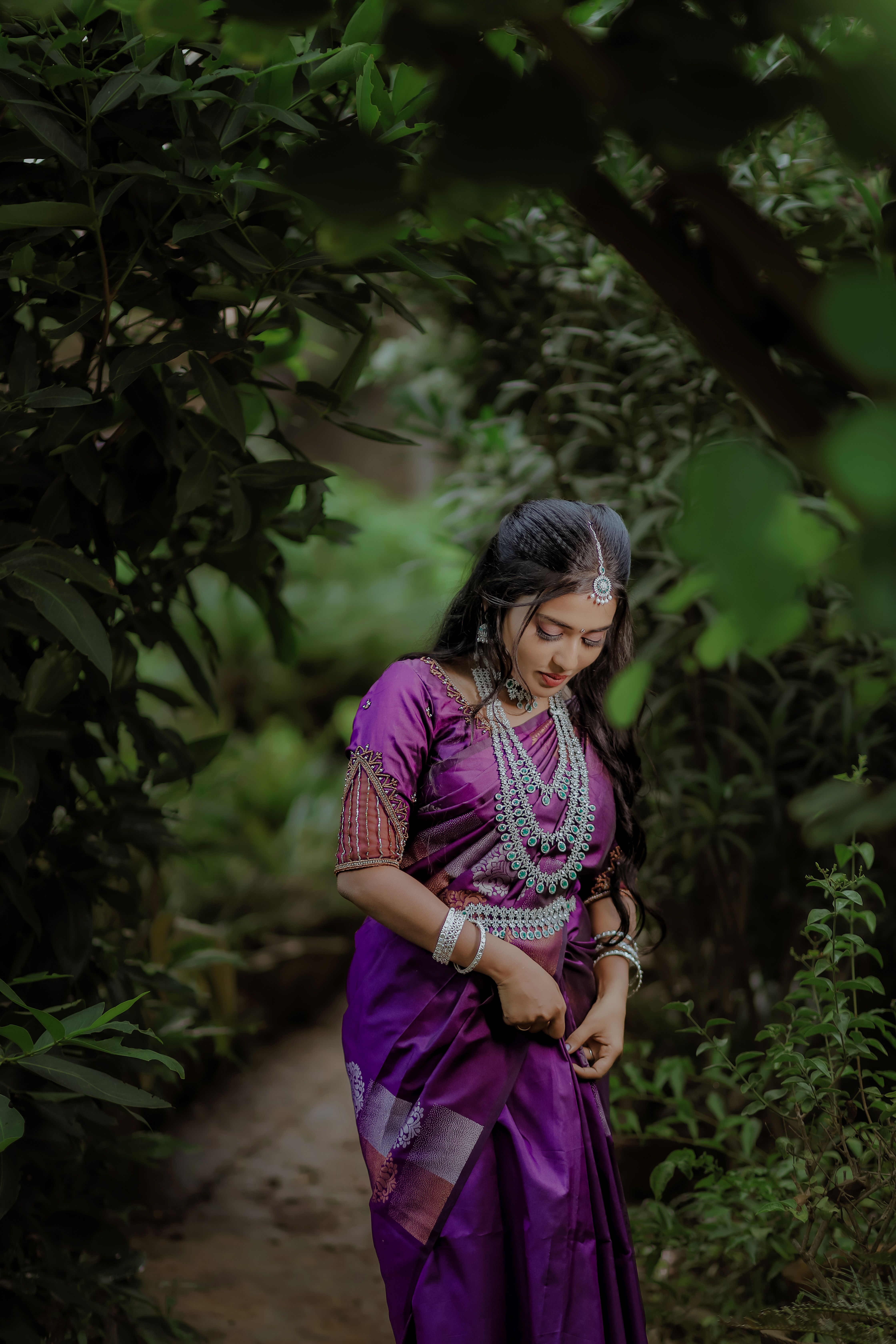 Beautiful Indian woman in traditional dress photographed outdoors, showcasing cultural elegance.