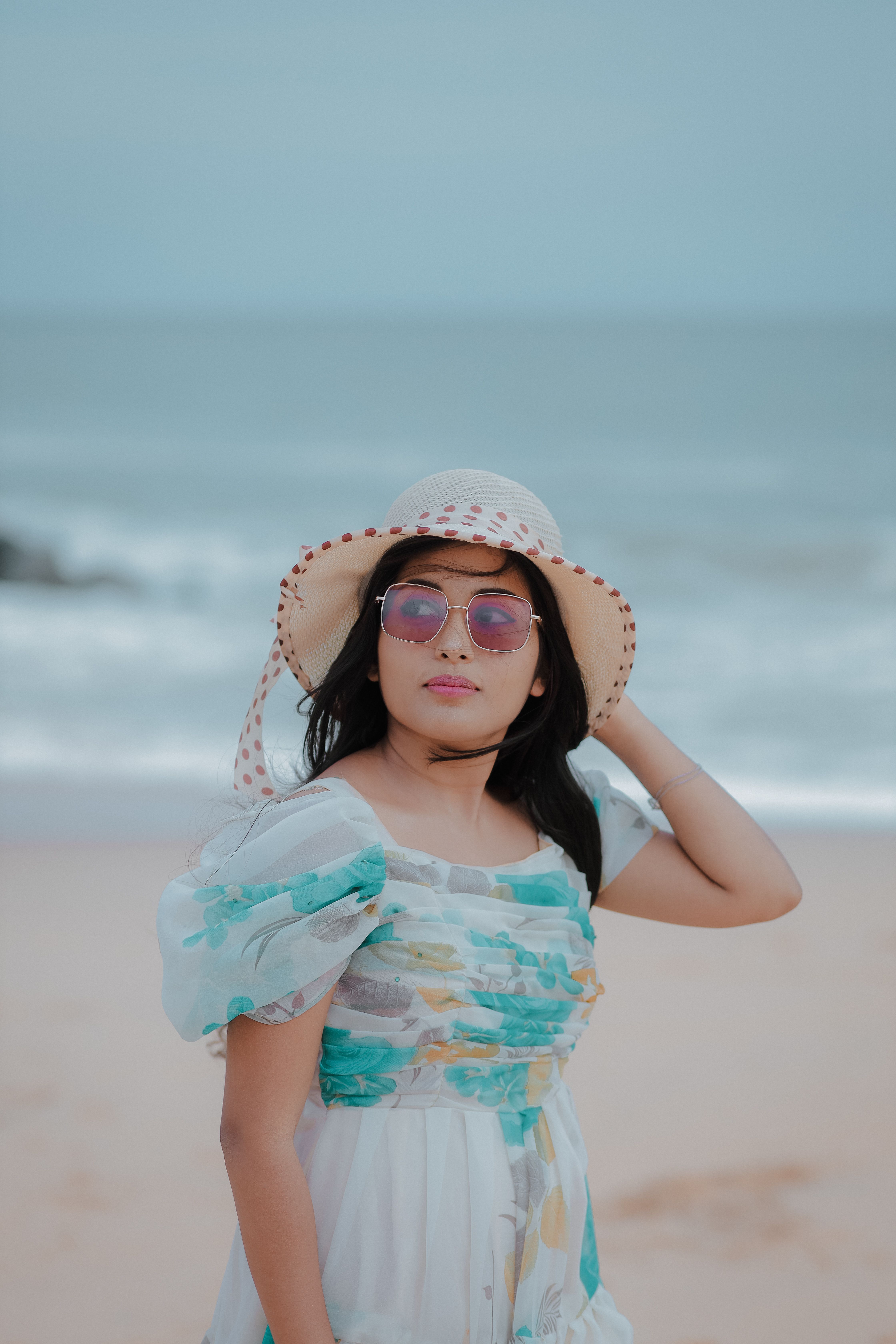 A woman in a hat and dress on the beach · Free Stock Photo