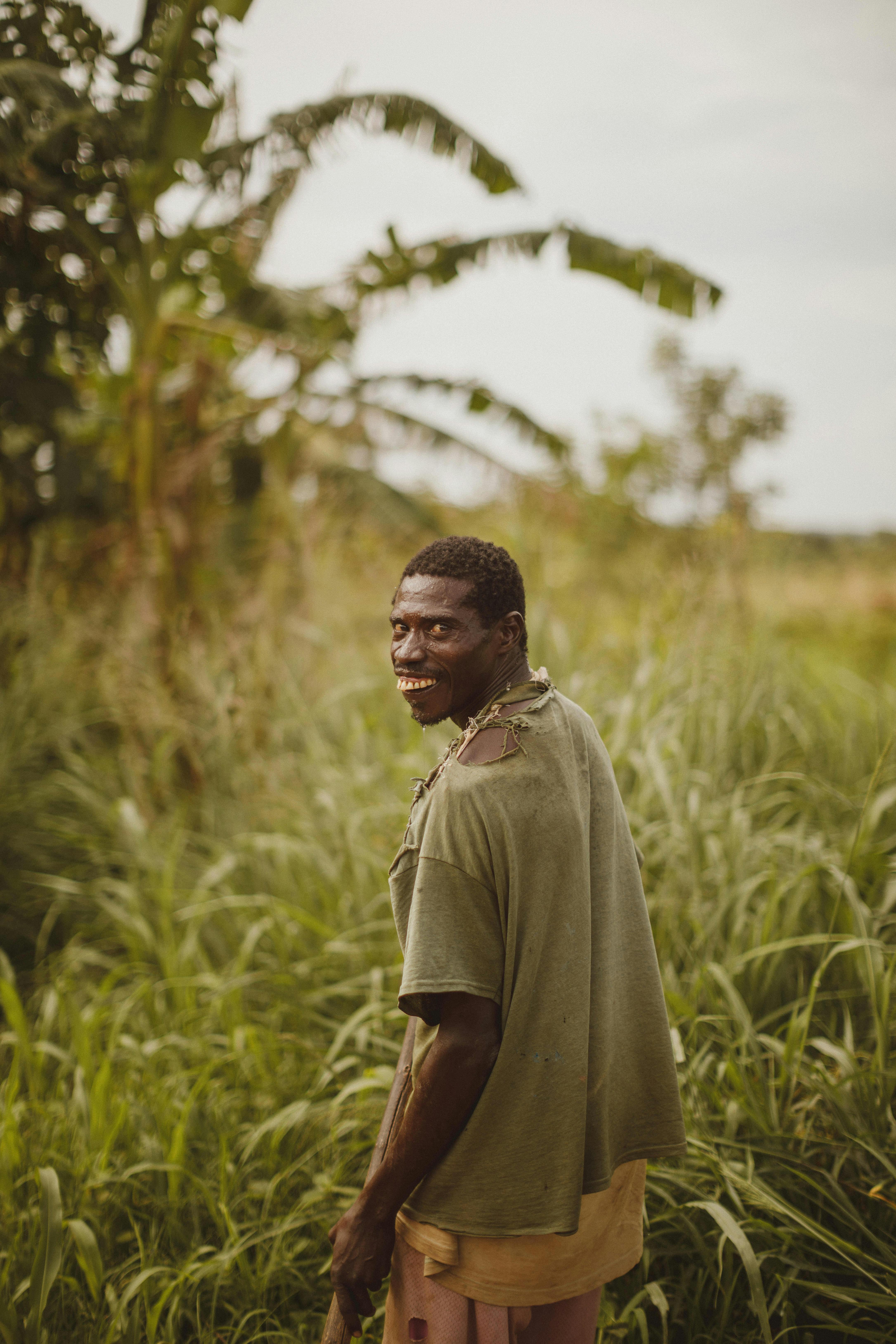 smiling man in t shirt standing on field