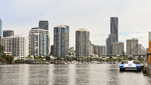 Free Contemporary urban skyline featuring tall buildings by the waterfront with a ferry docked nearby. Stock Photo