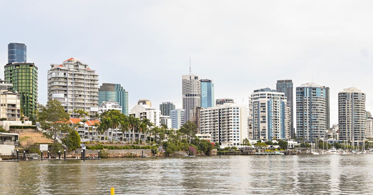Panoramic view of Brisbane skyline with modern skyscrapers from riverfront perspective.