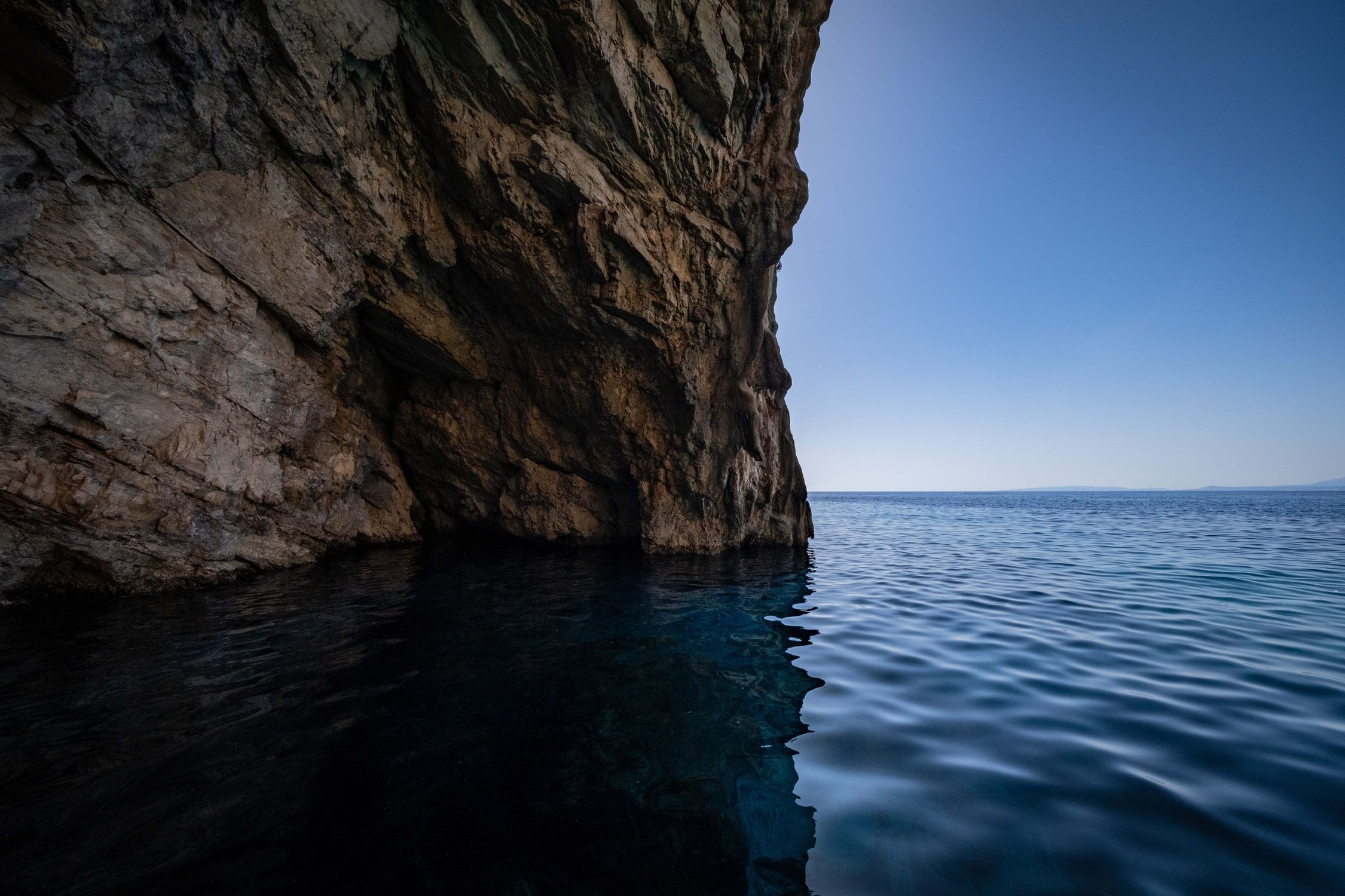 A cave with water in it and a blue sky · Free Stock Photo