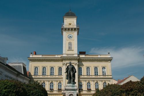 Free A scenic view of Komárno Town Hall with a prominent statue under blue skies, Slovakia. Stock Photo