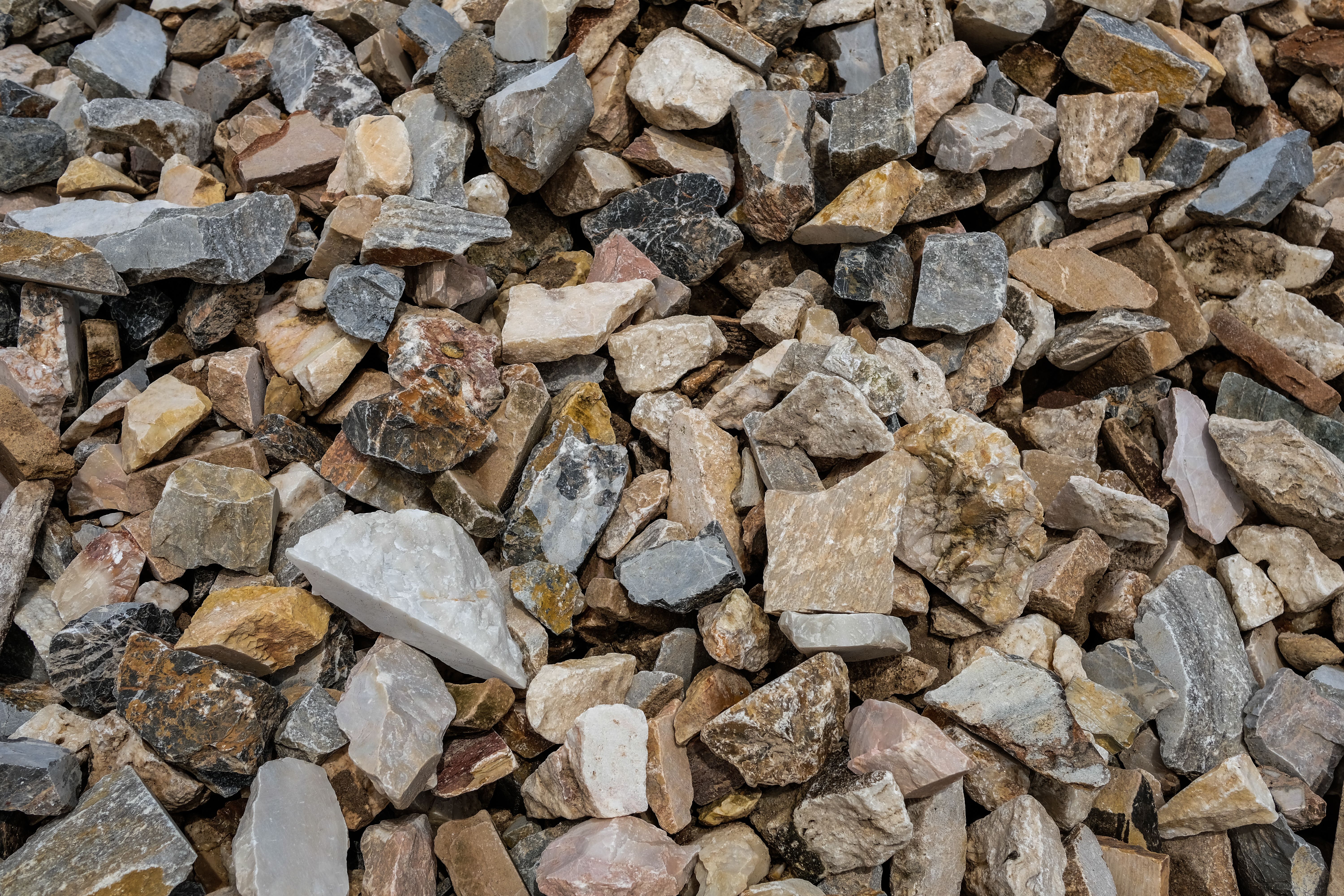 A diverse collection of natural stones with a rough and textured appearance.
