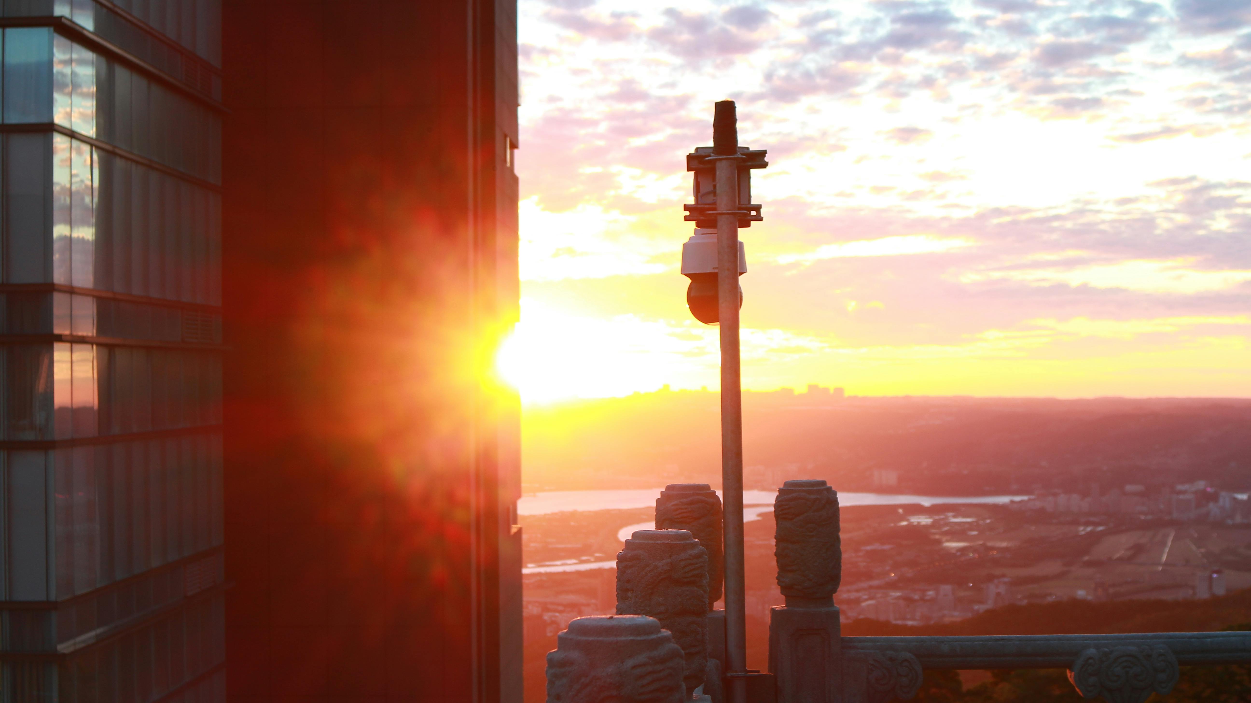 日落时分，城市景观令人叹为观止，太阳耀斑引人注目，现代建筑熠熠生辉